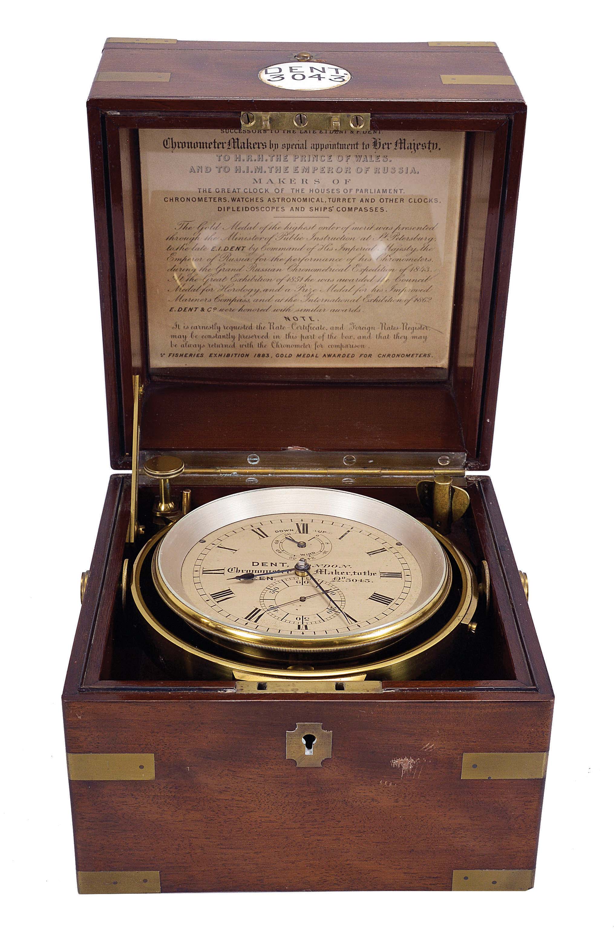 Dent, London, a good two day marine chronometer with Dent's staple balance, 11 jewel, spotted fusee movement with Earnshaw's escapement, freesprung bimetallic staple balance with blued helical balance spring and diamond endstone, Roman numeral silvered dial with wind indicator, blued steel spade and poker hands, with lacquered brass bowl and gimbals, and contained in a three tier mahogany and mahogany veneer box with brass furniture, the front with round plaque marked "Dent 3043", the inside of the lid with E. dent &amp; Co. label — Antique Clocks Price Guide