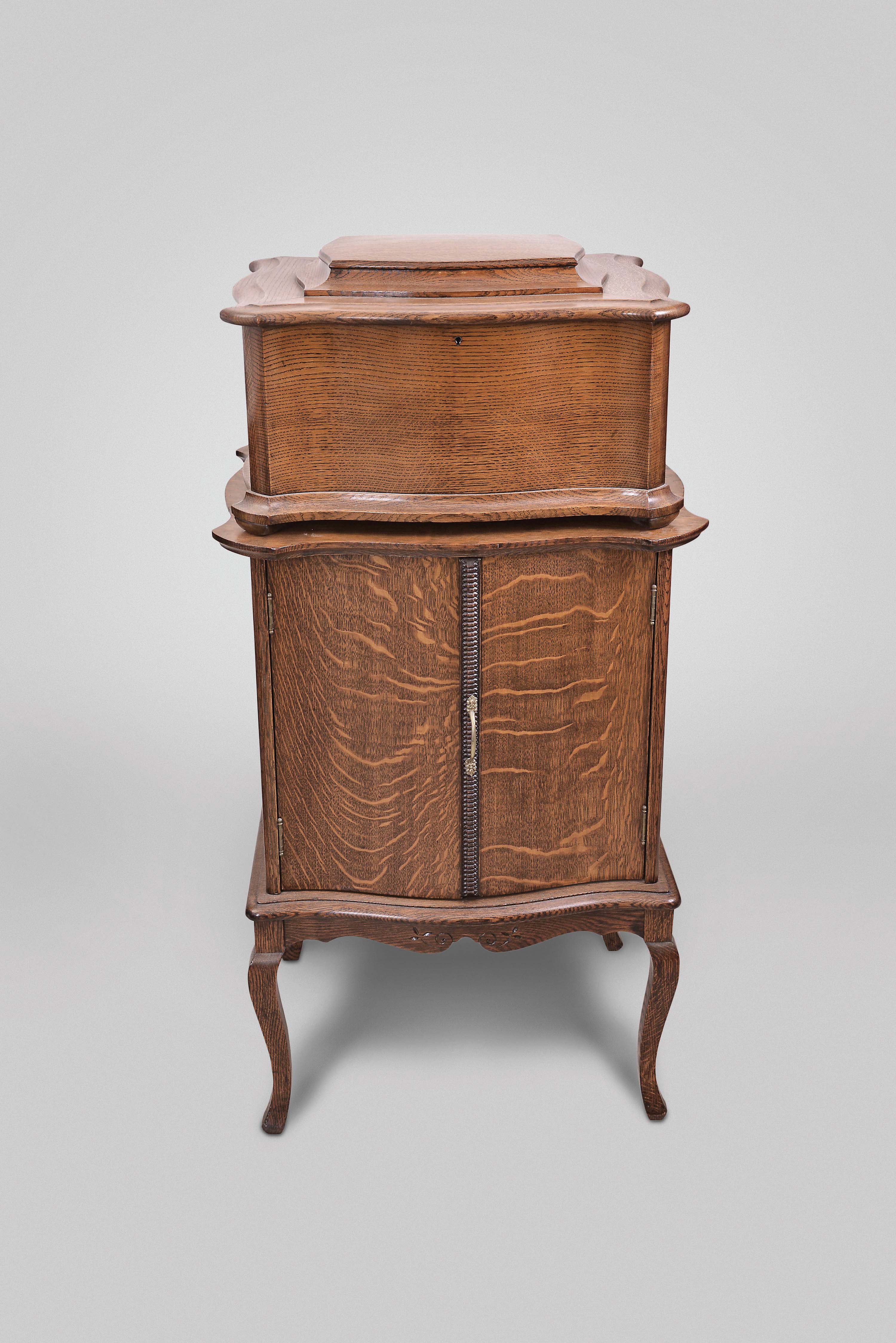Regina Music Box Company, Rahway, N.J., "Style 50" table top music box, playing 15.5 inch discs on a double comb, short bed plate, spring wound movement in quarter sawn oak serpentine case with matching disc cabinet, with 35 discs including many waltzes. — Antique Clocks Price Guide