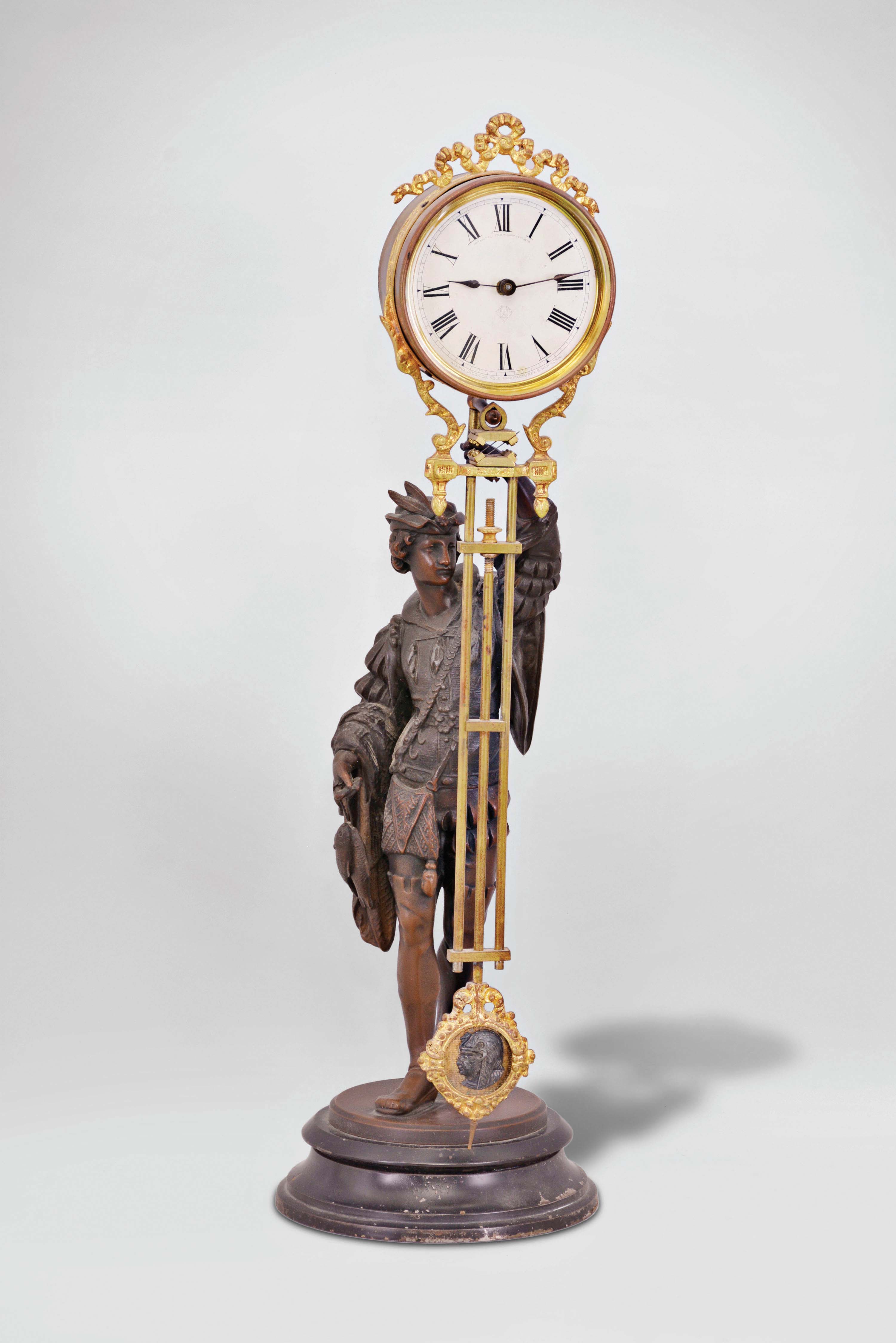 Ansonia Clock Co., New York, "Fisher" swinger shelf clock with a spring driven, 8 day, timepiece movement in a gilt and nickel cannister-style case with a bronze finished spelter statue on a black enameled iron base. — Antique Clocks Price Guide