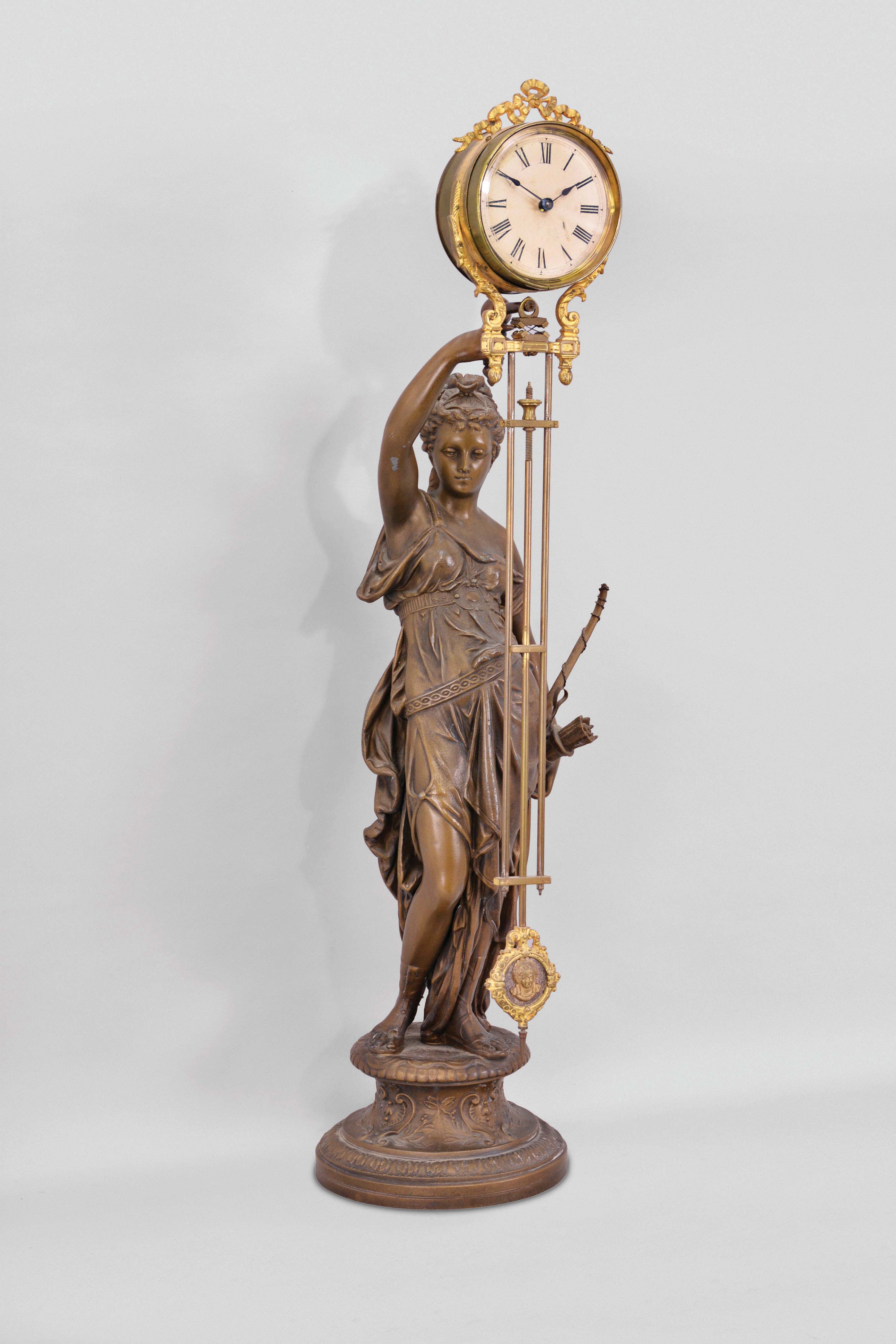 Ansonia Clock Co., New York, "Diana" swinger shelf clock with a spring driven, 8 day, timepiece movement in a gilt and nickel cannister-style case with a bronze finished spelter statue on base. — Antique Clocks Price Guide