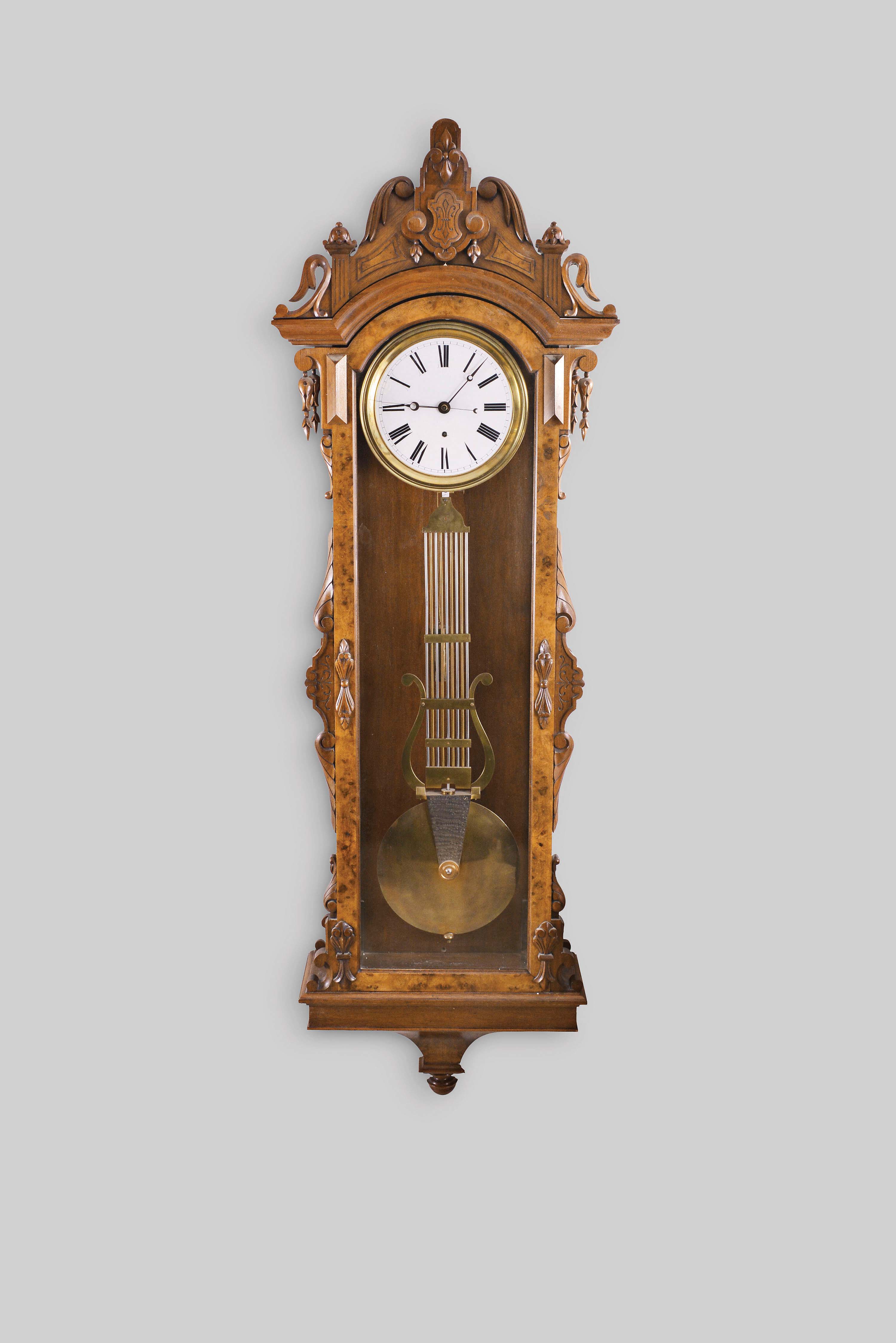 Ansonia Clock Co., New York, "Regulator No. 14", hanging jeweler's regulator, 8 day, time only, brass weight driven Swiss movement with pinwheel escapement, gridiron lyre pendulum and sweep seconds in a carved walnut and burl walnut case with a white enamel dial — Antique Clocks Price Guide