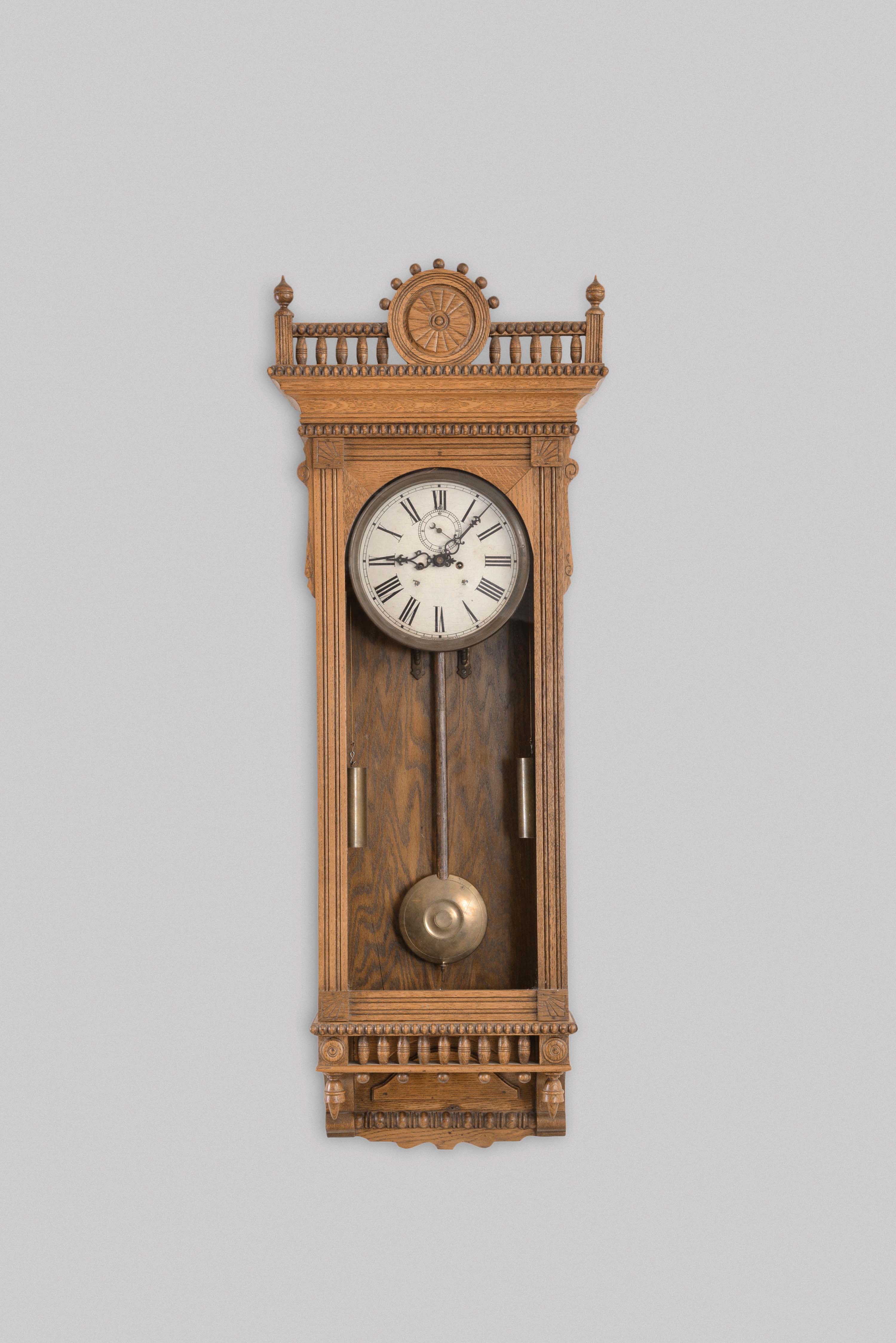 Waterbury Clock Co., Waterbury, Conn., "Regulator No. 53" wall clock, 8 day, time only, weight driven movement in an oak case with a painted metal dial and enameled beat indicator — Antique Clocks Price Guide