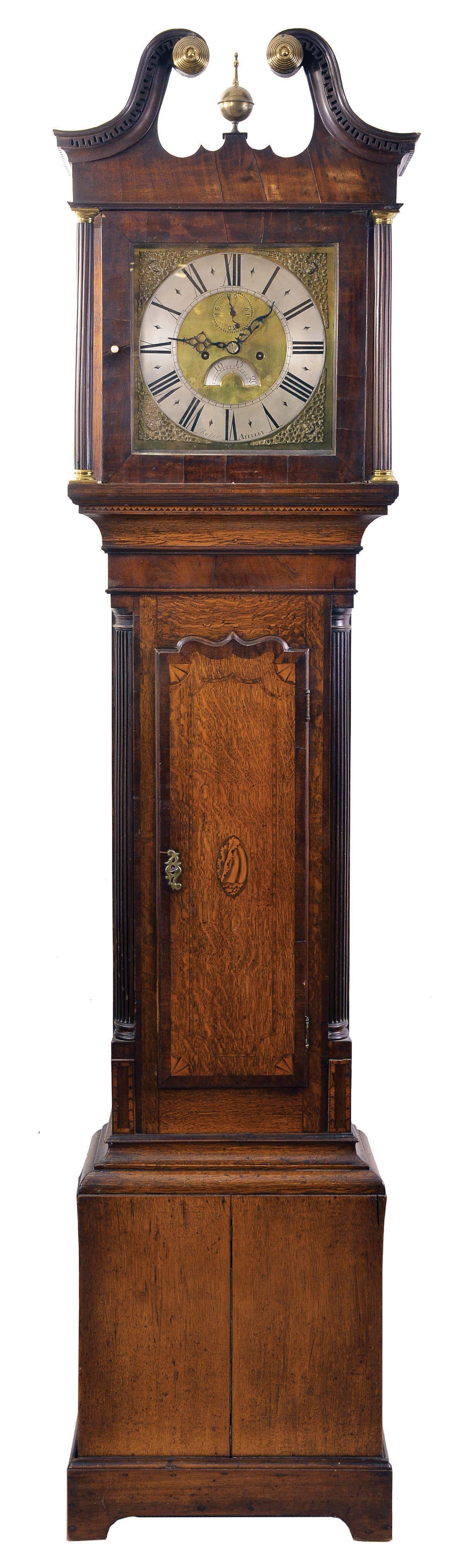 Joseph Baker, Appleby, (County Westmorland), England, tall clock, 8 day, time and strike, weight driven movement in a mahogany and oak veneer case with a dental molded broken arch pediment, brass rosettes and center finial, two fluted columns with brass capitals flanking hood over an inlaid oak and mahogany trunk, fluted columns flanking trunk door resting on straight bracket feet. The brass dial has a silvered chapter ring, date aperture and cast corner spandrels. — Antique Clocks Price Guide