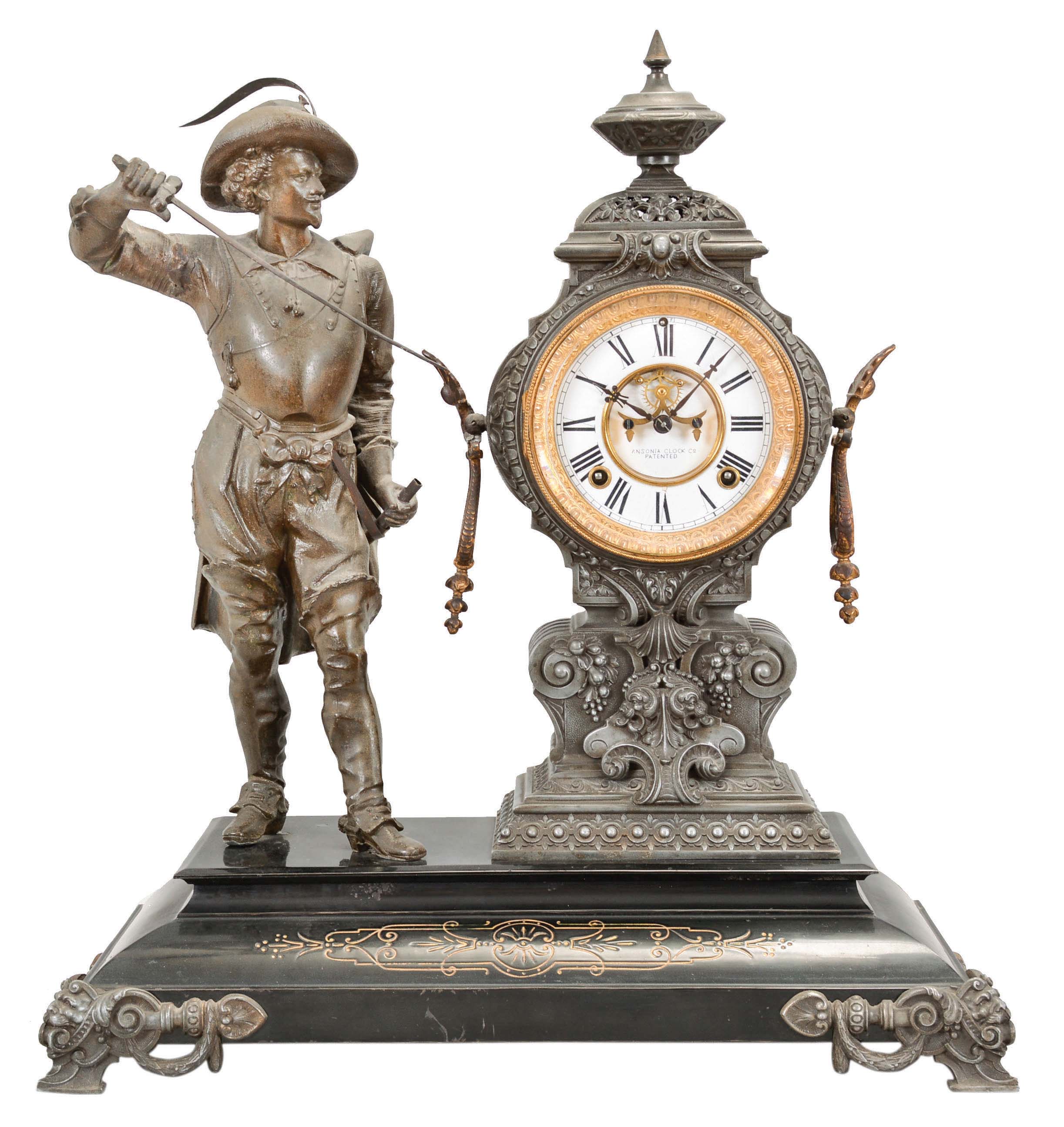 Ansonia Clock Co., New York, "Don Caesar" Figure shelf clock with a spring driven, 8 day, time and half hour strike movement with visible escapement with a black enameled iron base with a Japanese bronze spelter statue. — Antique Clocks Price Guide