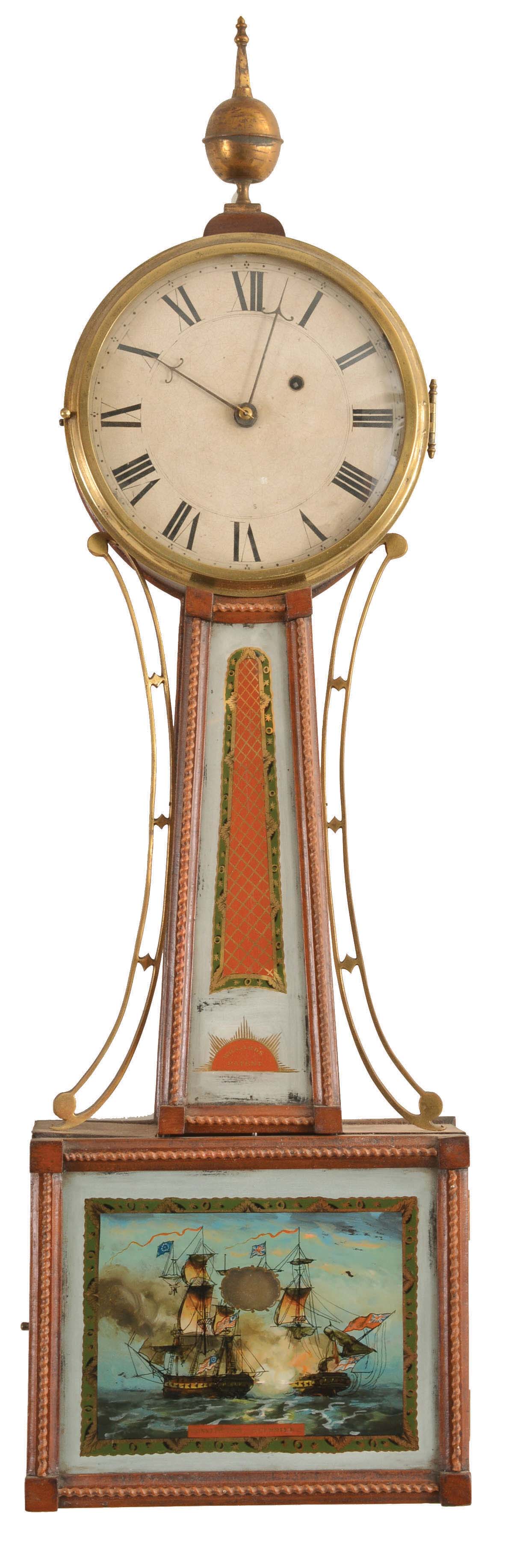 Unsigned, probably Massachusetts, 8 day, weight driven brass movement patent timepiece, with mahogany case and gilt, rope molded frames, cast brass side arms, cast brass bezel, and brass ball and spire finial, throat glass with green and gilt bordered lattice on a red ground above a red rising sun style ornament with gilt rays, and signed "Willard's Patent", the lower glass with matching border and depicting the battle between the USS Constitution and the HMS Guerriere, white painted roman numeral dial with steel barbed hands, and brass clad pendulum. — Antique Clocks Price Guide