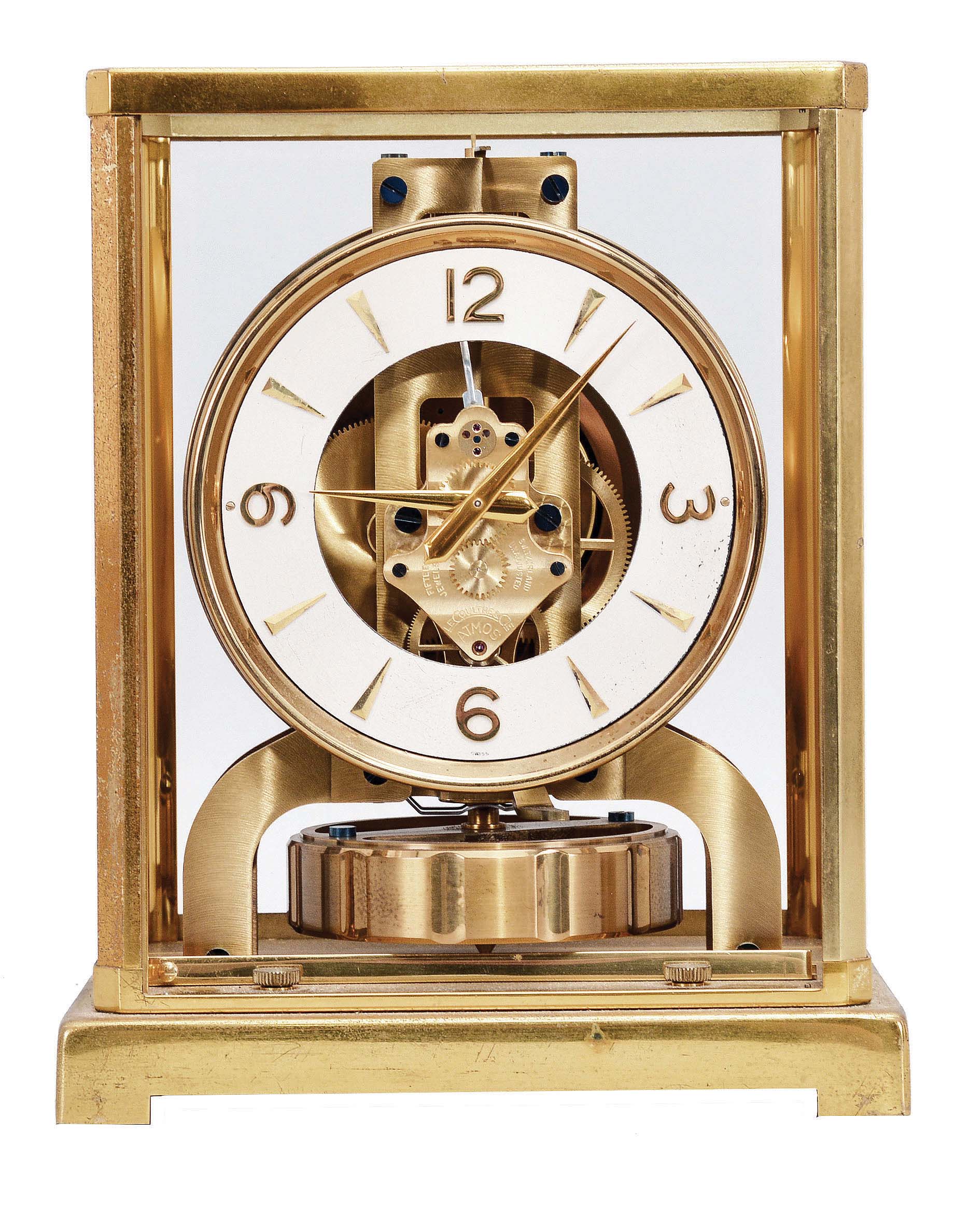 Jaeger- LeCoultre, Switzerland, "Atmos" clock, 15 jewel, caliber 526-5 movement, gilt torsion pendulum, round white painted dial with applied gilt Arabic numerals and arrow markers, gilt hands, all contained in a glazed rectangular case, movement serial #83424. — Antique Clocks Price Guide