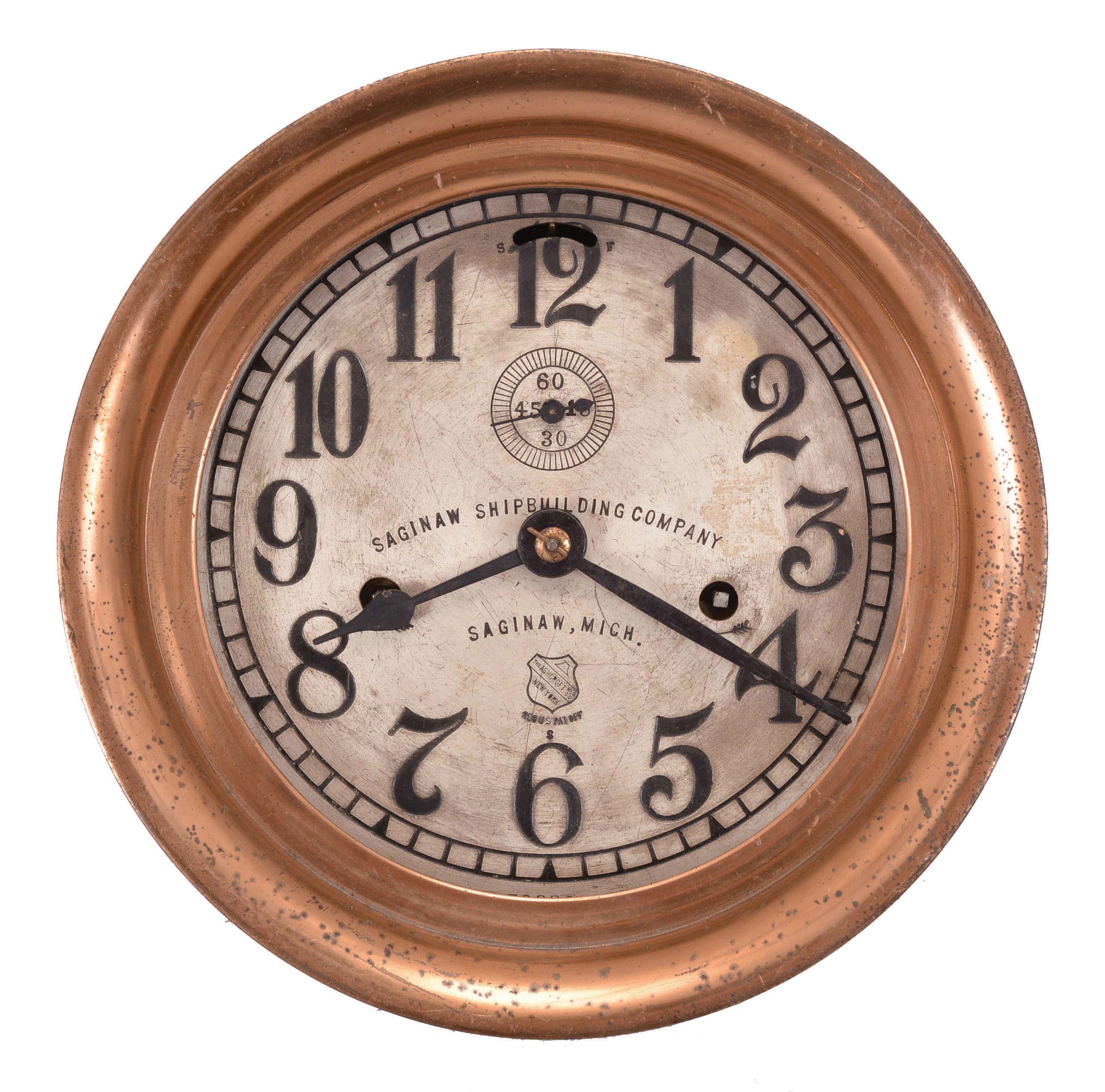 Seth Thomas Clock Co., Thomaston, Conn., for Ashcroft Mfg. Co., New York, engine room clock, 8 day, time only, twin spring-driven balance wheel movement in a heavy red brass case with locking hinged bezel, 6.5 inch silvered dial with Arabic numerals, subsidiary seconds, with the Ashcroft trademark and block lettering reading "Saginaw Shipbuilding Company / Saginaw, Mich.". — Antique Clocks Price Guide