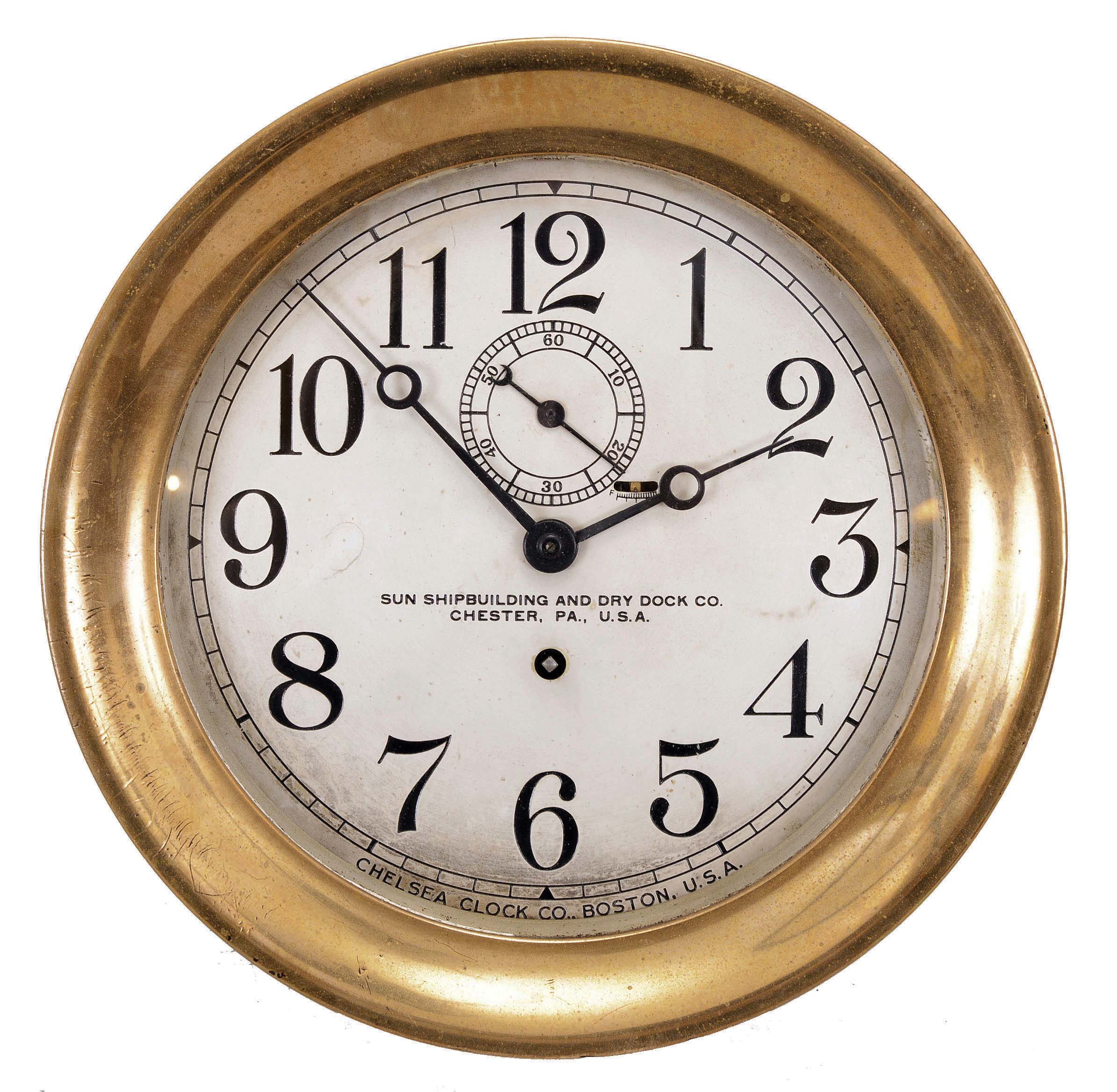 Chelsea Clock Co., Boston, Mass., deck clock, 8 day, time only, spring-driven jeweled balance wheel movement in a brass case with hinged bezel, 7.5 inch silvered dial with white Arabic numerals, subsidiary seconds, reading "SUN SHIPBUILDING AND DRY DOCK CO. / CHESTER, PA., U.S.A." — Antique Clocks Price Guide