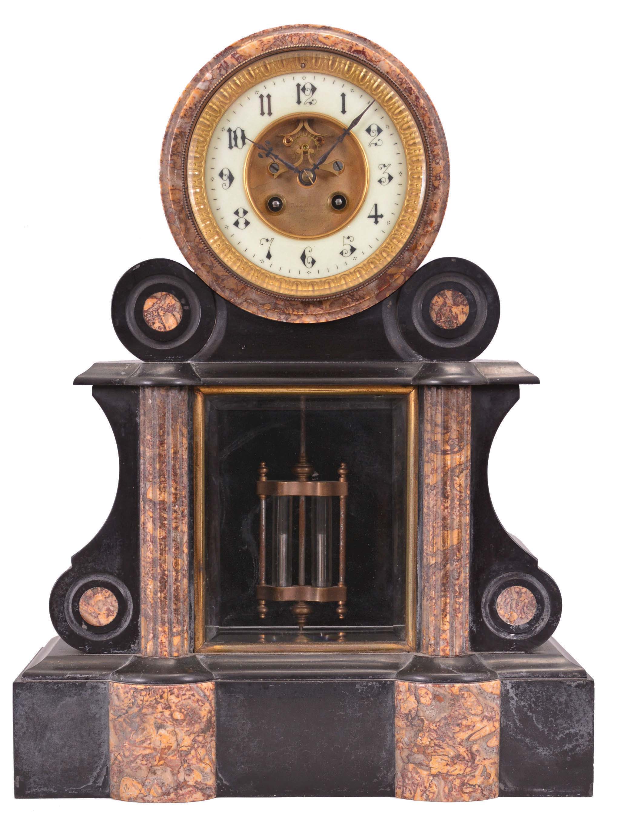 AD Mougin, Paris, mantel clock, 8 day, time and bell strike, spring-driven pendule de Paris movement with visible Brocot escapement in a black marble case with fluted red and yellow marble half columns flanking a beveled glass viewing window for the double-vial pendulum, the cream porcelain dial with Arabic numerals and matching marble surround mounted within a drum head form, the time displayed by blued steel hands. — Antique Clocks Price Guide