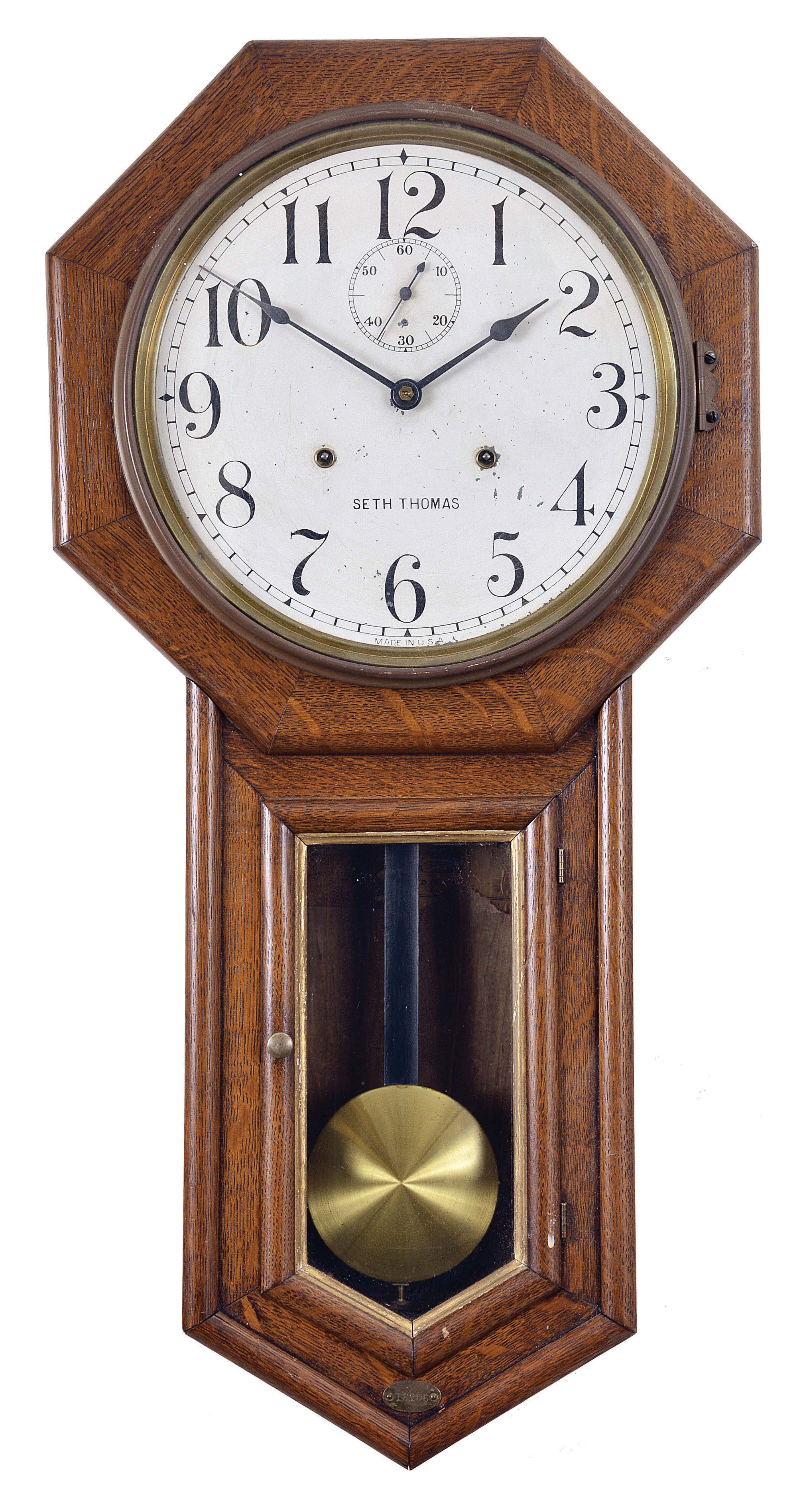 Clocks- 2 (Two): (1) Seth Thomas Clock Co., Thomaston, Conn., "World" wall hanging clock with a spring driven, 30 day timepiece movement in an oak case, c1917. (2) Ansonia Clock Co., New York, "Regulator A" hanging clock with a spring driven, 8 day, time and strike movement in a walnut case, c1900. — Antique Clocks Price Guide