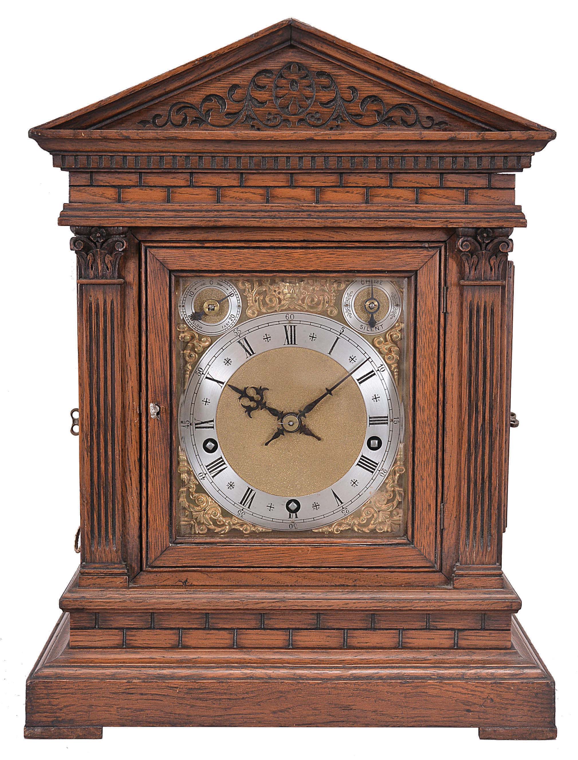 Winterhalder &amp; Hofmeier, Schwarzenbach, Germany, bracket clock, 8 day, time and gong strike with chime playing on eight bells, spring-driven movement in an oak architectural case with fluted pilasters, frieze resembling ashlar, tympanum with carved scroll design, brass dial plate with applied cast spandrels, silvered chapter ring with Roman numerals, subsidiary rate adjustment and chime / silent dials, blued steel hands. — Antique Clocks Price Guide