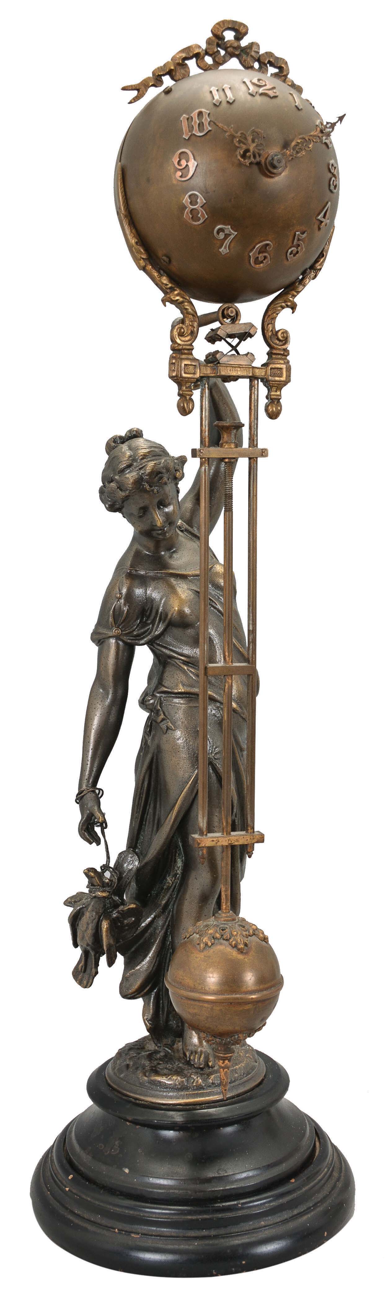 Ansonia Clock Co., New York, "Huntress" figural swinger, 8 day, time only, spring-driven movement mounted inside a brass sphere with cast ribbon ornament and applied Arabic numerals, Louis XV style hands, held aloft by a patinated spelter figure of a young woman carrying game birds in her other hand, standing on an ebonized cast iron base. — Antique Clocks Price Guide