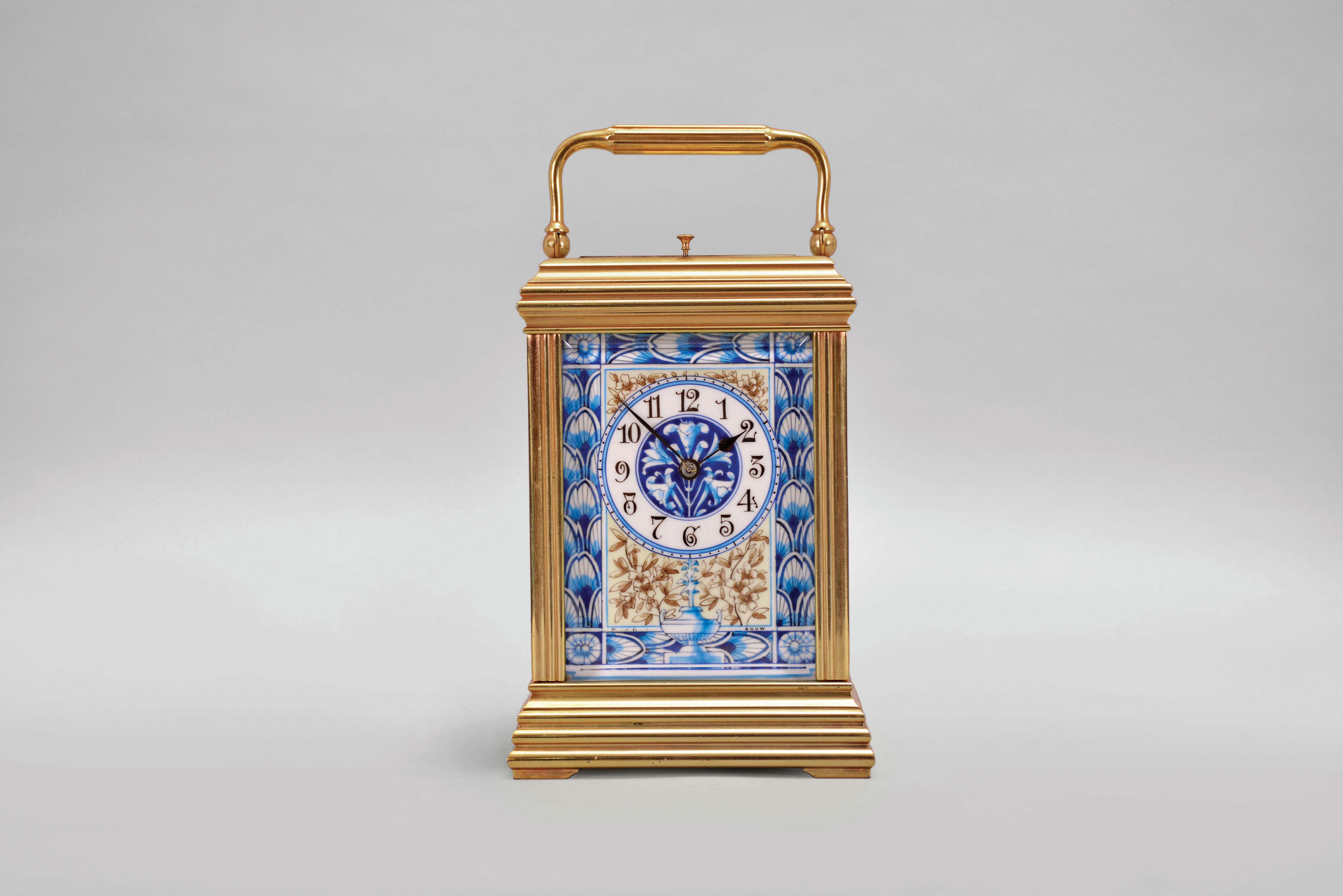 France, attributed to Gaye, Lamaille, &amp; Co., a fine, Aesthetic Movement, porcelain paneled hour repeating carriage clock, the gilt, Cannelee variant case with folding handle, the sides set with panels depicting a potted flower in blue, on a cream ground, also with floral ornament, and with blue, wheatear border, the Arabic numeral dial with ornament matching the side panels, blued steel spade and whip hands, two train, 8 day movement with lever platform, striking the hour and half hour in passing, and repeating the last hour on demand, the back plate marked "Patent Surety Roller", and 1813 — Antique Clocks Price Guide
