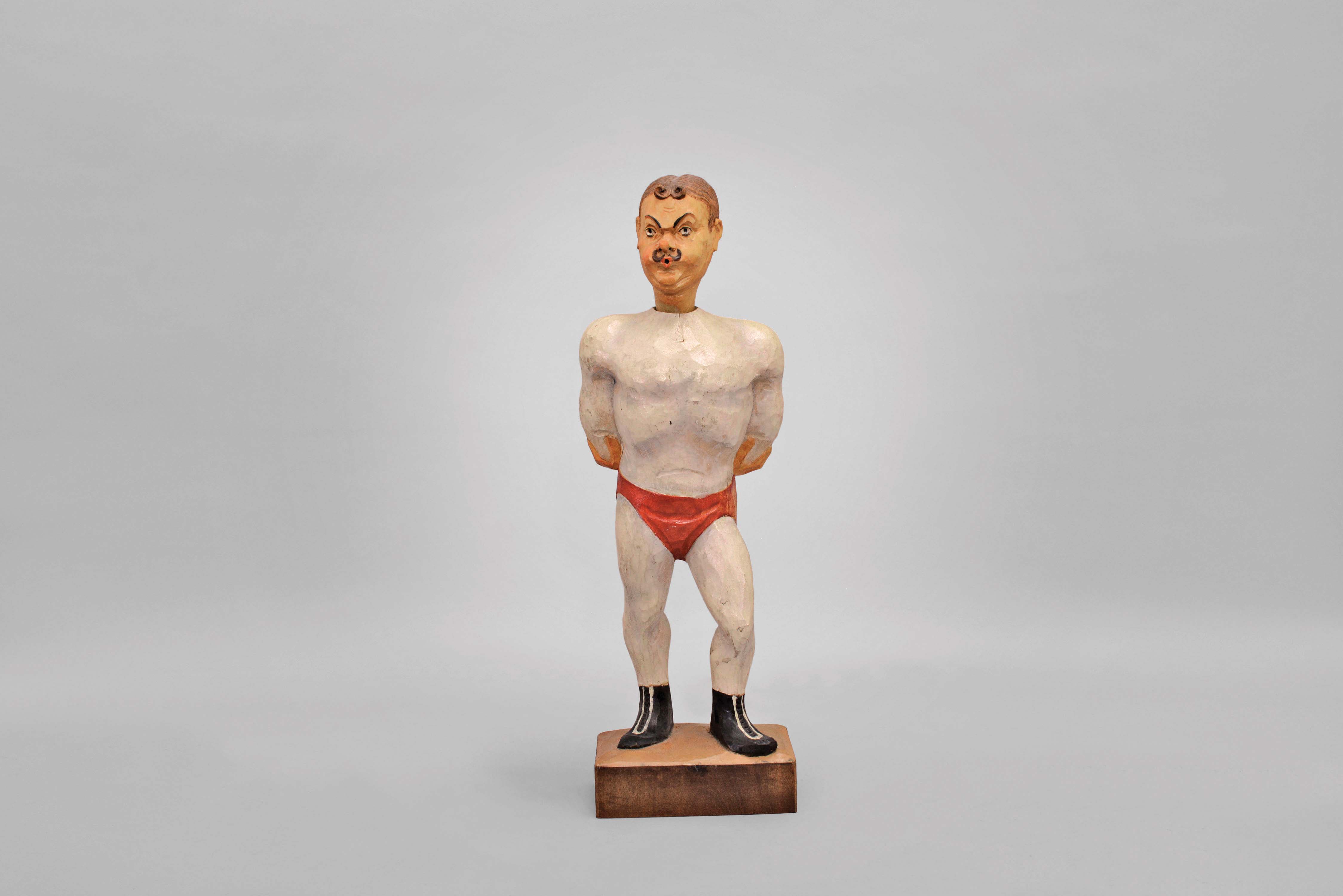 Whistler- Germany, carved wood whistler figure of a strong man or a trapeze artist powered by a spring driven movement. Though it is not signed except for "Germany" most of these were made by Karl Griesbaum. — Antique Clocks Price Guide