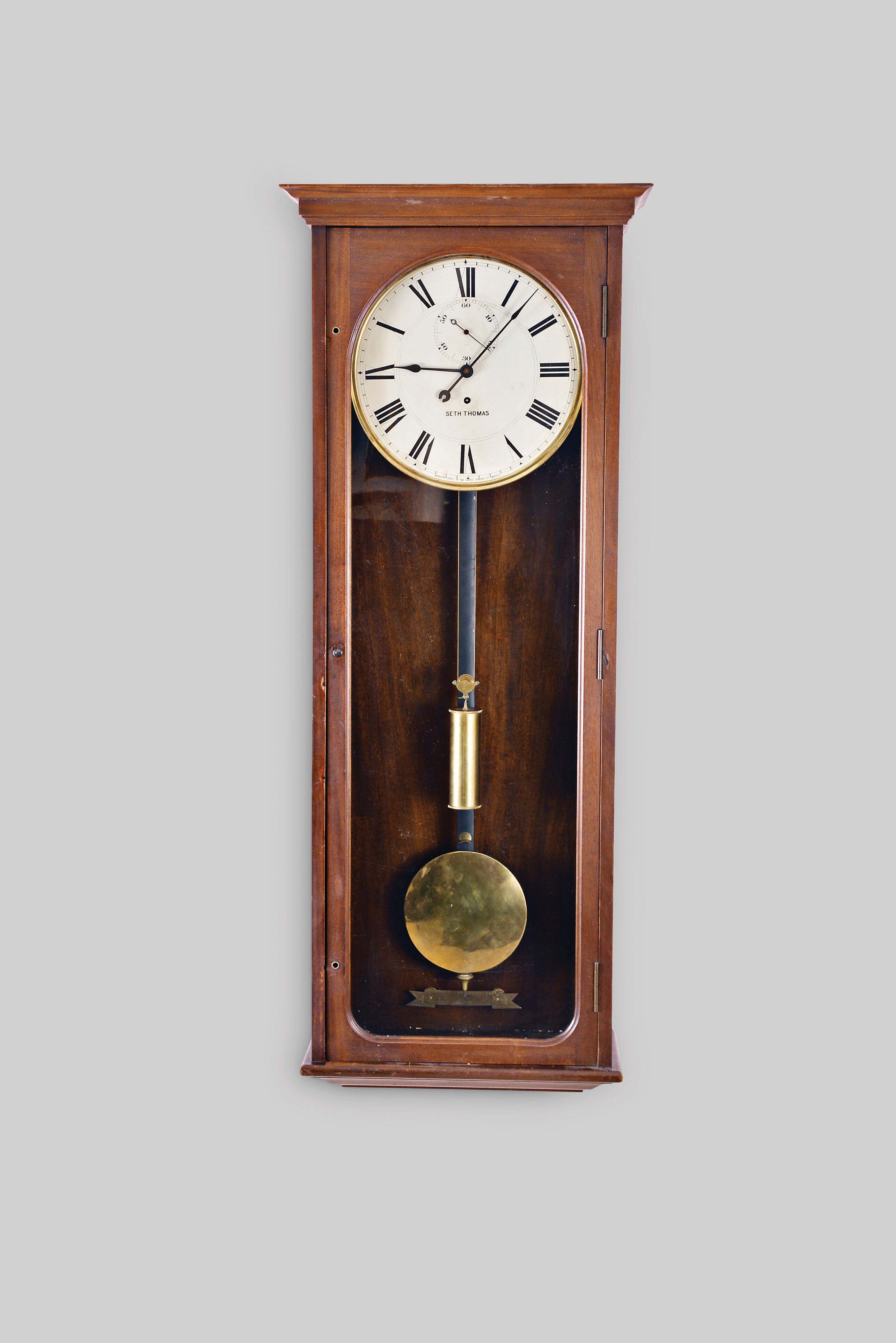 Seth Thomas Clock Co., Thomaston, Conn., "Regulator No. 70", wall clock, 8 day, time only, brass weight driven movement in a mahogany case with a painted metal dial and large engraved brass beat scale — Antique Clocks Price Guide
