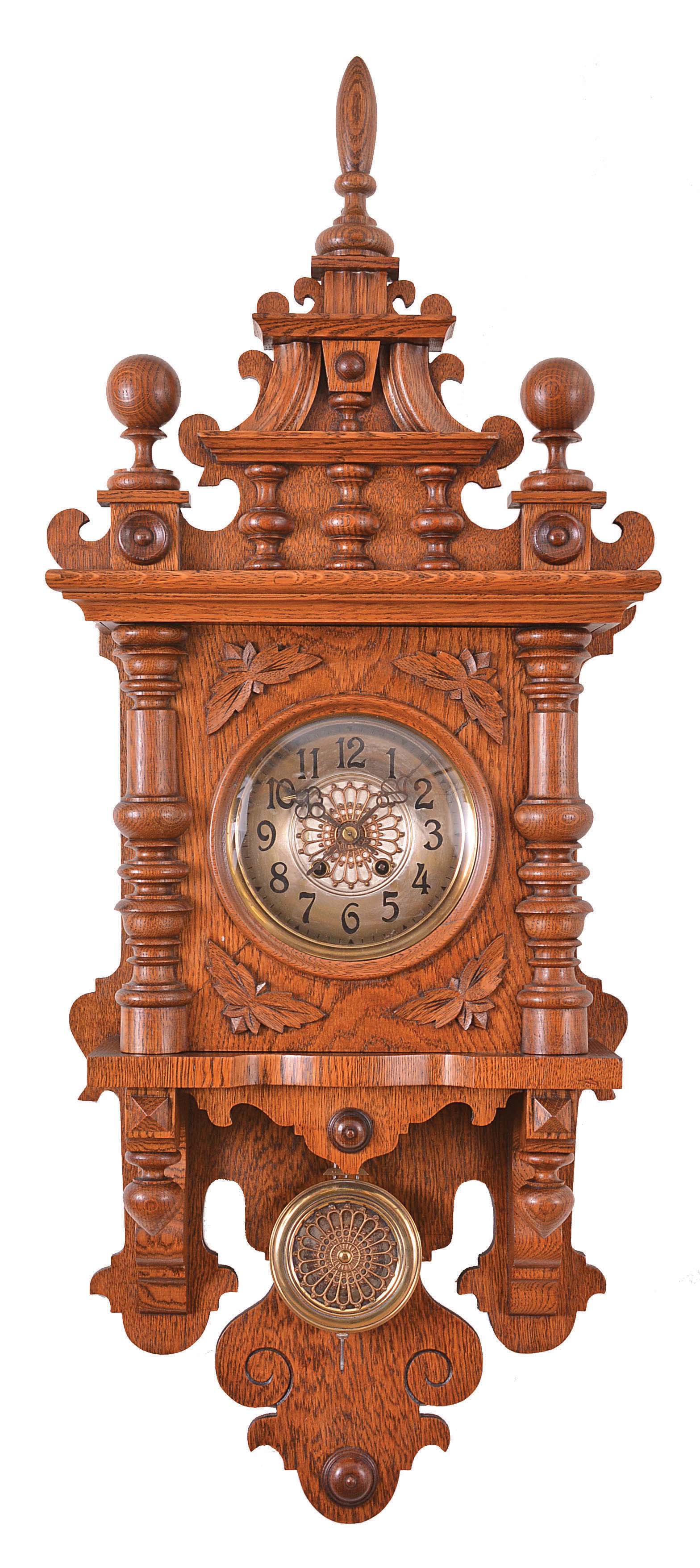 Clocks- 2 (Two) German Free Swingers: (1) Carl Werner Uhrenfabrik, Villingen, Germany, "freischwinger" wall clock, 8 day, time and strike, spring driven movement in an oak case with turned and carved ornaments, fancy brass pendulum, c1890. (2) Germany, freischwinger wall clock, 8 day, time and strike, spring driven movement in a walnut case with applied brass ornaments, c1900. — Antique Clocks Price Guide
