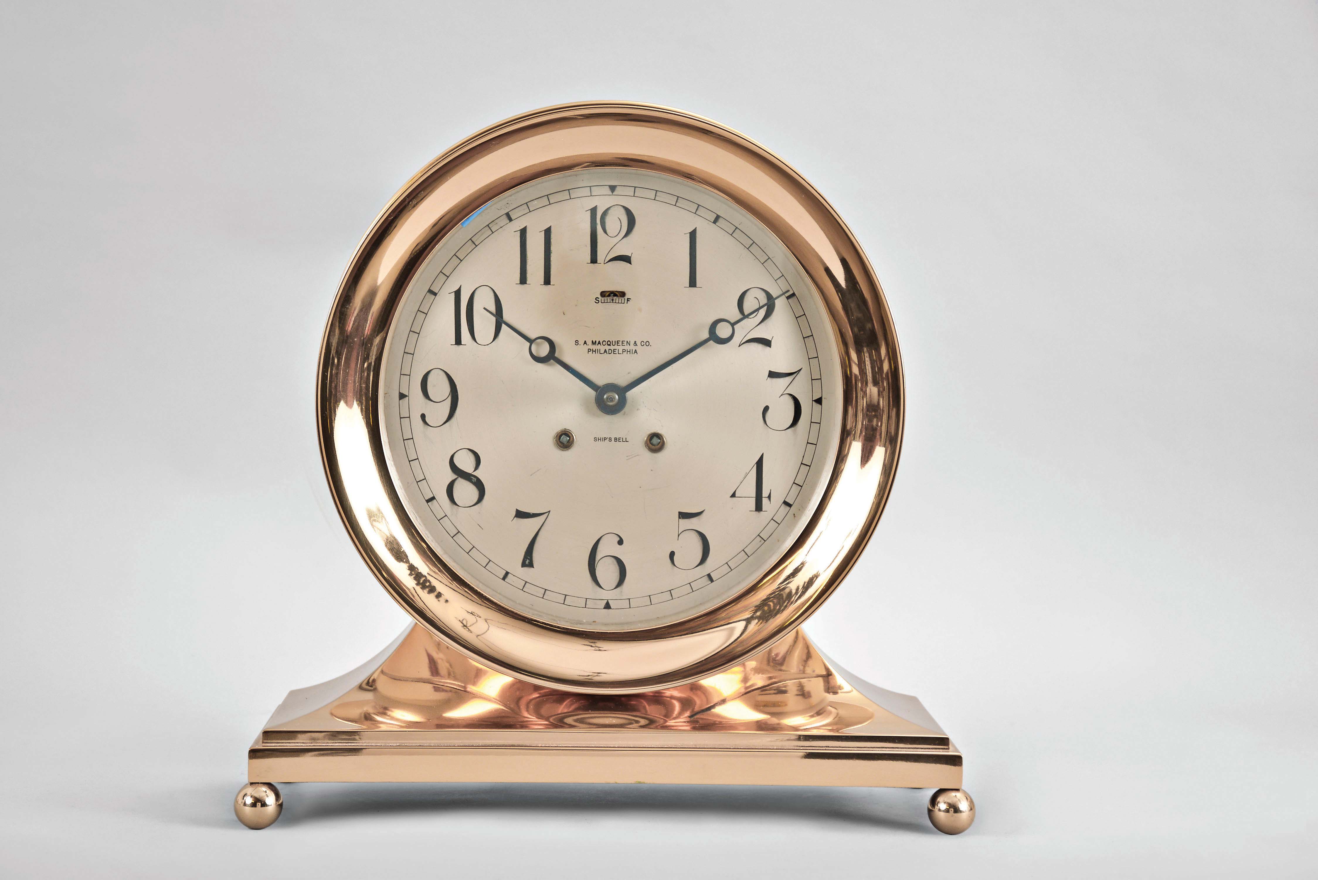 Chelsea Clock Co., Chelsea, Mass., "Commodore Base &amp; Ball", 8 day, time and strike brass lever movement ship's bell mantel clock with an 8 1/2" dial retailed by S. A. MacQueen &amp; Co., Philadelphia. Serial No. 86426. — Antique Clocks Price Guide