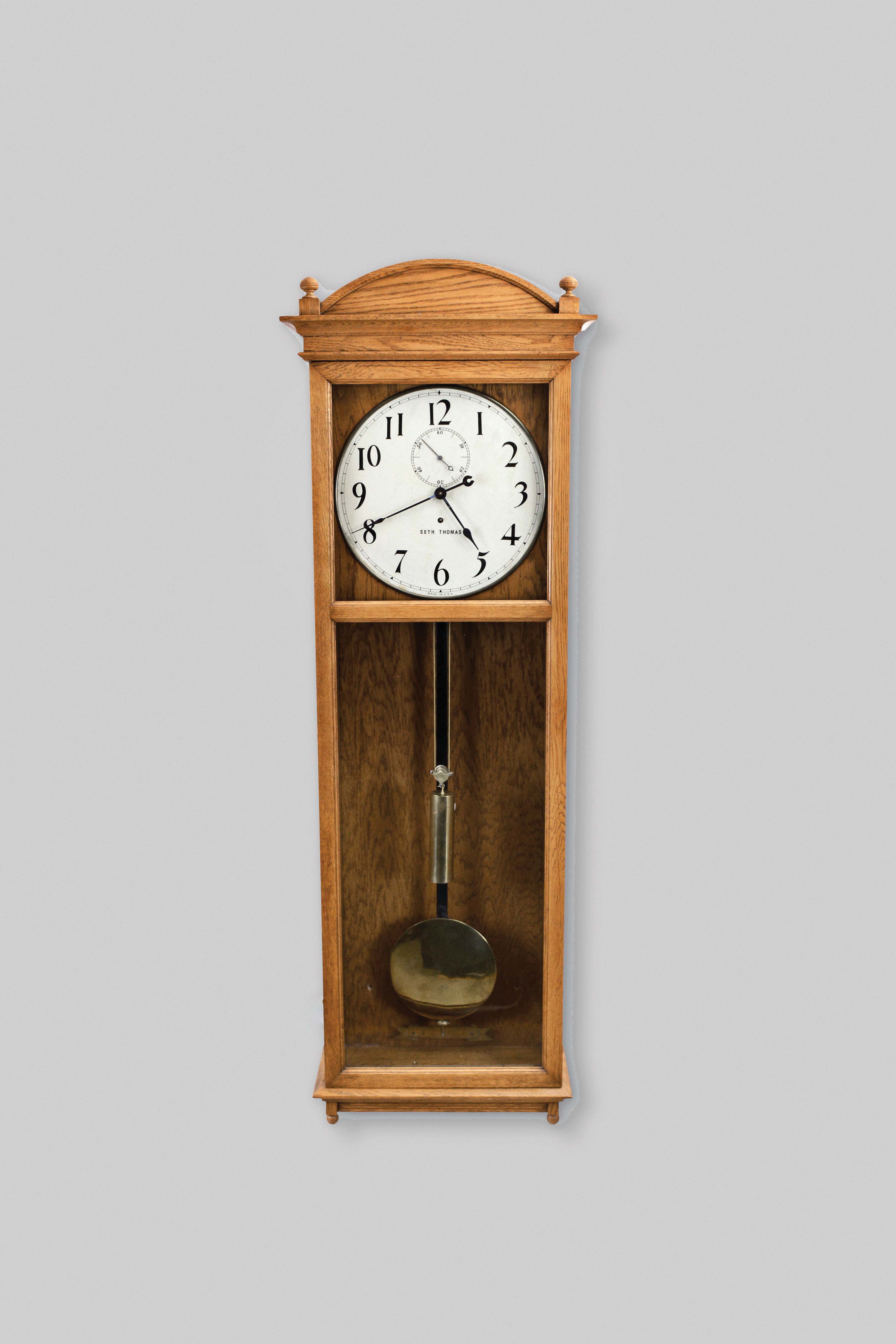 Seth Thomas Clock Co., Thomaston, Conn., "Regulator No. 20" hanging clock with a weight driven, 8 day, timepiece movement with Graham dead-beat escapement and maintaining power in an oak case. — Antique Clocks Price Guide