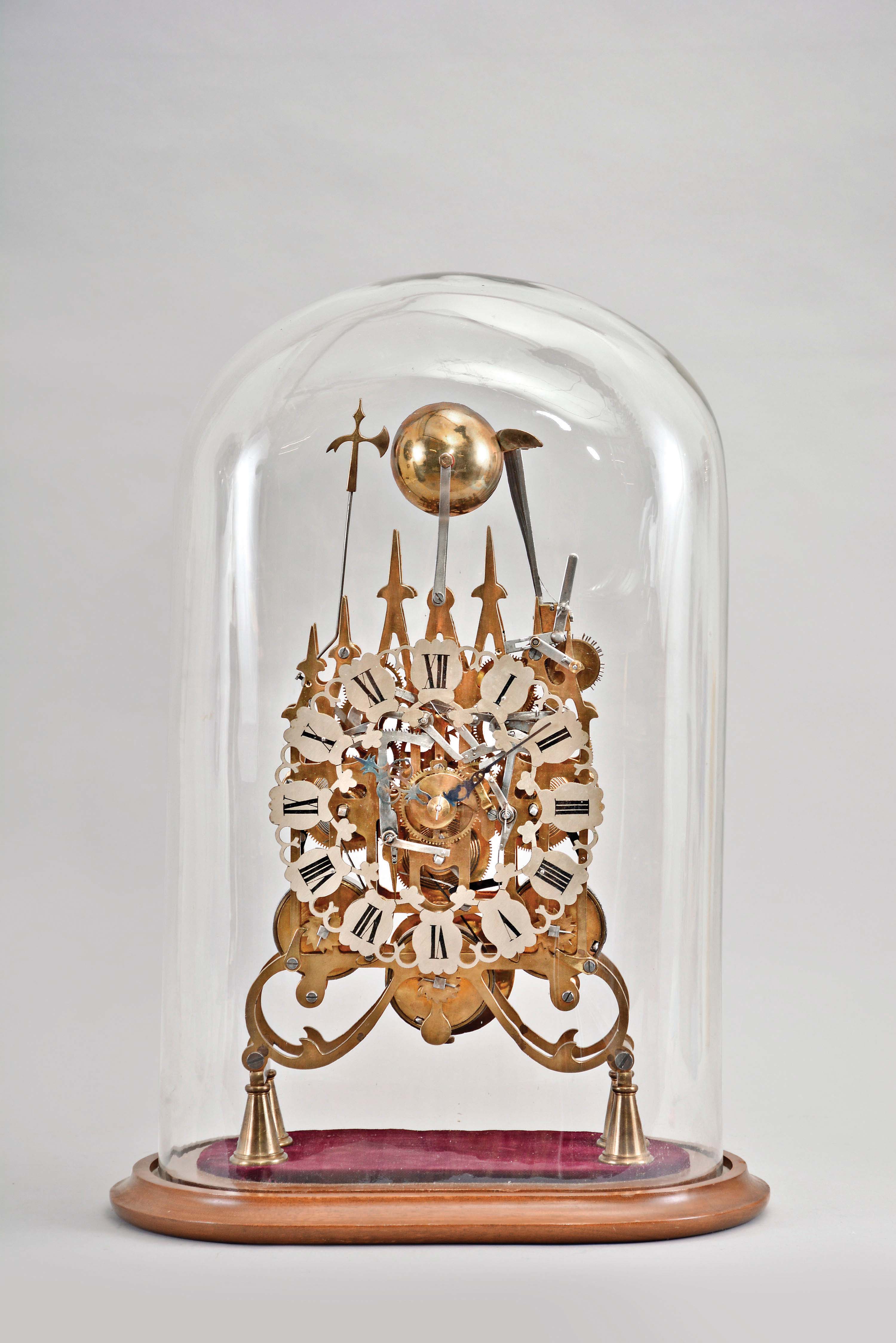 Modern reproduction skeleton clock, 8 day, time and strike with chime on eight bells, triple fusee spring driven movement in a pierced brass frame mounted on a velvet covered, cavetto molded wood base, all under a glass dome. — Antique Clocks Price Guide