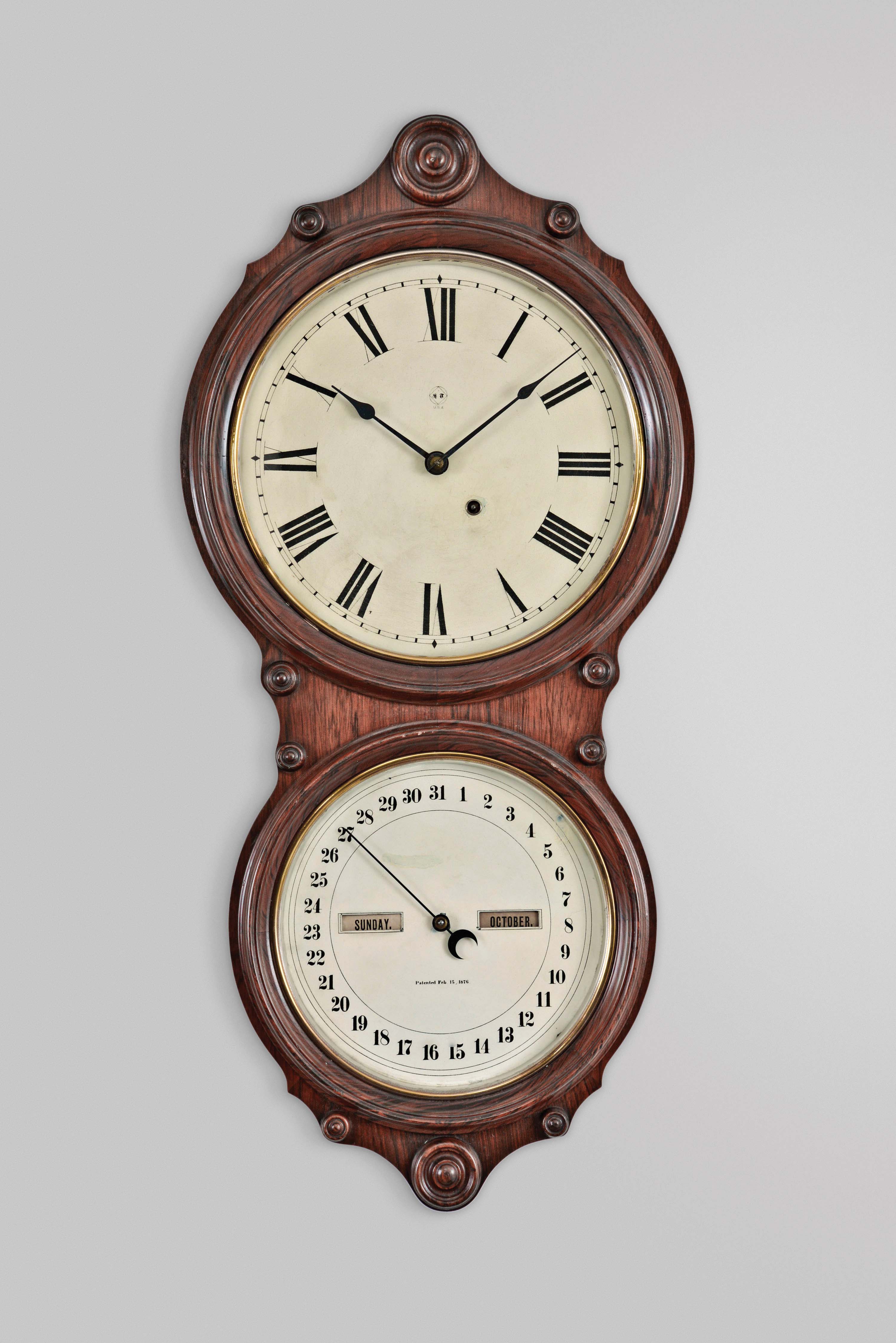 Seth Thomas Clock Co., Thomaston, Conn., "Office Calendar No. 6" hanging clock with a spring driven, 8 day, timepiece movement and an R. T. Andrews 1876 patent perpetual calendar mechanism in a rosewood veneered case. — Antique Clocks Price Guide