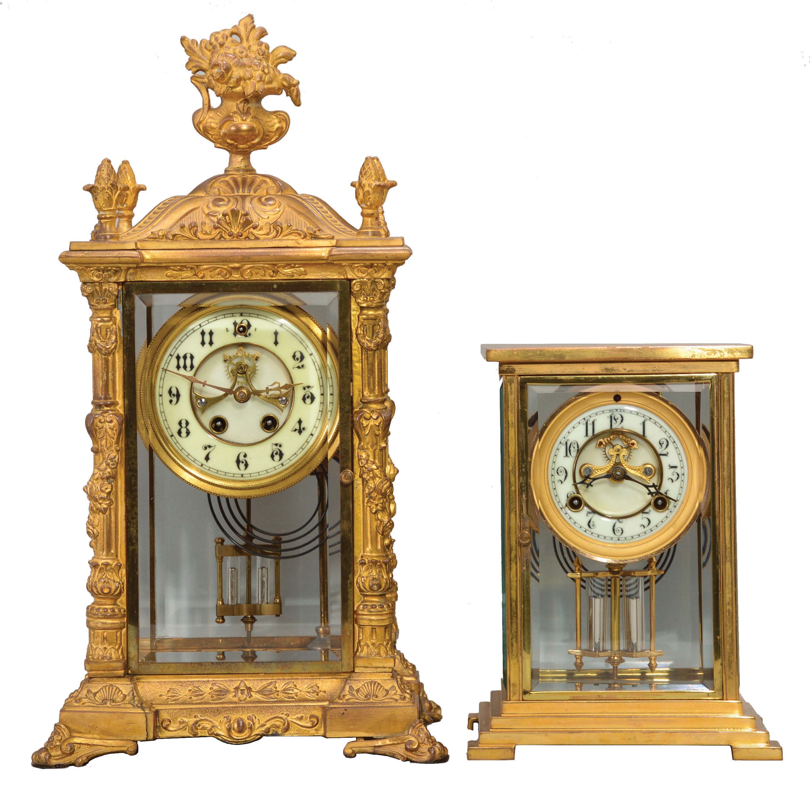 Clocks- 2 (Two): (1) William L. Gilbert Clock Co., Winsted, Conn., "Verdi", 8 day, time and strike, spring brass movement crystal regulator with visible escapement, c1906 (2) Waterbury Clock Co., Waterbury, Conn., "Navarre", 8 day, time and strike, spring brass movement crystal regulator with visible escapement, c1906 — Antique Clocks Price Guide