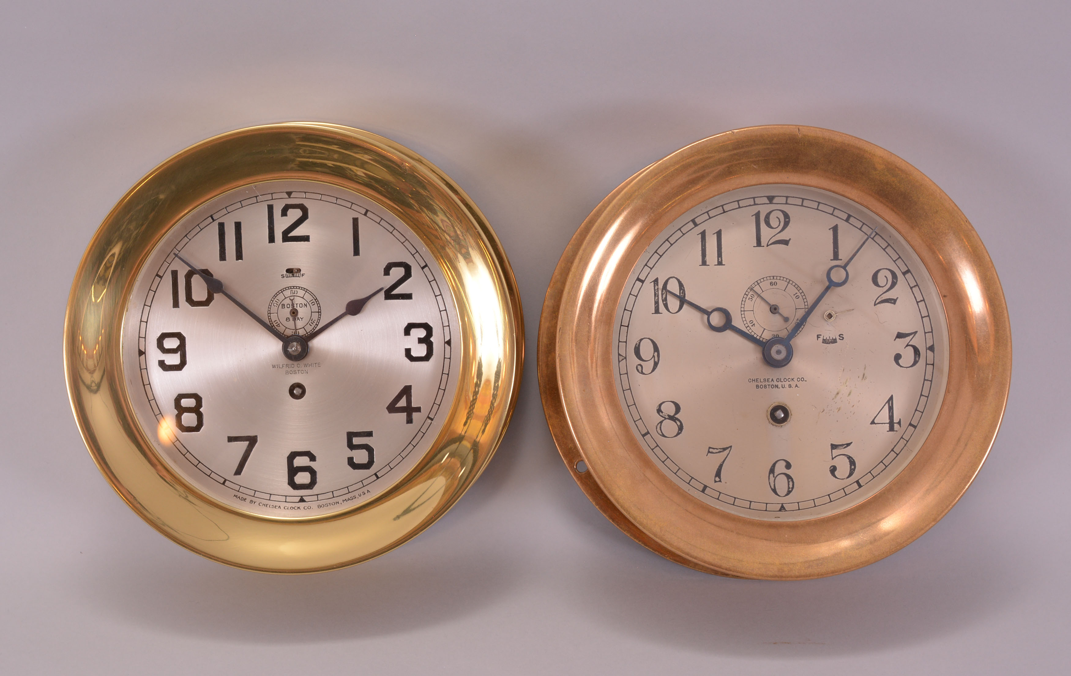 Clocks- 2 (Two) Boston and Chelsea: (1) Boston Clock Co., Boston, Mass., 8 day, time only, spring driven movement with a jeweled lever escapement in a brass case with screw-on bezel, 6 inch silvered dial signed "Boston / 8 Day" within the subsidiary dial and Wilfred O. White / Boston" below the center arbor, blued steel spade hands, movement serial number 22497B, c1919. (2) Chelsea Clock Co., Boston, Mass., 8 day, time only, spring driven movement with a jeweled lever escapement in a brass case with screw-on bezel, signed 6 inch silvered dial with subsidiary seconds, blued steel Breguet style hands, movement serial number 111751, c1917. — Antique Clocks Price Guide
