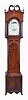New Jersey or New York tall clock, 8 day, time and strike, weight driven movement in a mahogany and mahogany veneer broken arch case with French feet, banded inlay around plinth, center panel, trunk and hood door, ebony striping on four full columns flanking hood, three brass finials, brass rosettes on broken arch and crotch mahogany trunk door and plinth. The painted metal dial has bird's nest in arch and painted floral spandrels and calendar disc under center arbor.