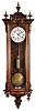 Gustav Becker, Freiberg, Germany, Vienna style regulator, 8 day, time only, weight driven movement in a walnut case with fluted columns flanking the door glass and turned ornaments, brass clad pendulum, white enamel dial reading in part "Breitinger & Kunz / Philadelphia", subsidiary seconds, and blued steel hands.