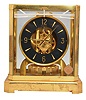 Jaeger- LeCoultre, Switzerland, "Atmos" clock, 15 jewel movement, gilt torsion pendulum, round black painted dial with applied gilt Arabic numerals and arrow markers, gilt hands all contained in a glazed rectangular case with removable front panel, serial #355823.