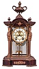 Ansonia Clock Co., New York, "Paragon" Crystal Regulator shelf clock with a spring driven, 8 day half hour strike movement with visible escapement in a bronze case with a rich gold finish and a mahogany base and top.