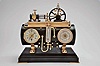 France, a rare, gilt and patinated, automated steam engine compendium, the horizontal boiler mounted to a cast floor with crosshatched surface, and resting on a black slate base, boiler fitted with an 8 day, timepiece and aneroid barometer, both with silvered dials and flanking the central thermometer with silvered scale, and surmounted by the engine flywheel, governor, cylinder and valve, the flywheel, piston, and governor powered by a movement concealed in the cylinder, the motion started and stopped through the screw in the cylinder valve, the valve front with plaque marked "D. H. Depose"