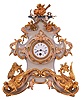 French mantel clock, the case and ornament of carved wood and finished to look like porcelain, with floral and rococo style ornament, and the base with winged dragons, with bright and matte gilding, gilt beaded bezel, Roman numeral white enamel dial, blued steel hands, 8 day, timepiece movement with pendulum