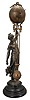 Ansonia Clock Co., New York, "Huntress" figural swinger, 8 day, time only, spring-driven movement mounted inside a brass sphere with cast ribbon ornament and applied Arabic numerals, Louis XV style hands, held aloft by a patinated spelter figure of a young woman carrying game birds in her other hand, standing on an ebonized cast iron base.