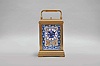 France, attributed to Gaye, Lamaille, & Co., a fine, Aesthetic Movement, porcelain paneled hour repeating carriage clock, the gilt, Cannelee variant case with folding handle, the sides set with panels depicting a potted flower in blue, on a cream ground, also with floral ornament, and with blue, wheatear border, the Arabic numeral dial with ornament matching the side panels, blued steel spade and whip hands, two train, 8 day movement with lever platform, striking the hour and half hour in passing, and repeating the last hour on demand, the back plate marked "Patent Surety Roller", and 1813