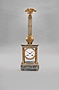Robin Pere, a Paris, a marble and gilt bronze mystery clock, the variegated, green marble, portico style case with fluted pilasters flanking the dial, and supporting the entablature, surmounted by a gilt column with eagle finial, with knife edge stud for suspending the gridiron pendulum, signed, Roman numeral white enamel dial with pierced and engraved gilt hands, 8 day, two train movement striking the hours and half hour in passing,