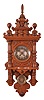 Clocks- 2 (Two) German Free Swingers: (1) Carl Werner Uhrenfabrik, Villingen, Germany, "freischwinger" wall clock, 8 day, time and strike, spring driven movement in an oak case with turned and carved ornaments, fancy brass pendulum, c1890. (2) Germany, freischwinger wall clock, 8 day, time and strike, spring driven movement in a walnut case with applied brass ornaments, c1900.
