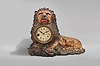 Bradley & Hubbard, Meriden, Conn., "Lion" blinking eye shelf clock, the polychrome painted, cast iron beast recumbent in a rocky landscape and appearing to hold the bow of a giant pocket watch in his mouth, his eyes connected to a lever on the pallet arbor, the rocking arbor imparting an up and down motion to the eyes, roman numeral, varnished paper dial with blued steel spade hands, and 30 hour pendulum timepiece.