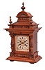 Gebrueder Junghans, Schramberg, Germany, mantel clock. 8 day, time and strike, spring driven movement in a walnut case with turned ornaments, polychrome paper dial, and blued steel hands.