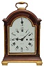 Samuel Toulmin, Strand, London, a Georgian mahogany bracket clock with enameled dial, the break arch case with polished brass furniture, and glazed sides, the case top and base molded on four sides, unusual white has Roman numerals, Arabic five minute markers, and strike/silent indicator in the arch, pierced, blued steel hands, two train fusee movement with verge escapement, the back plate engraved with acanthus, flowers, and C scrolls, and striking the hours on a bell.