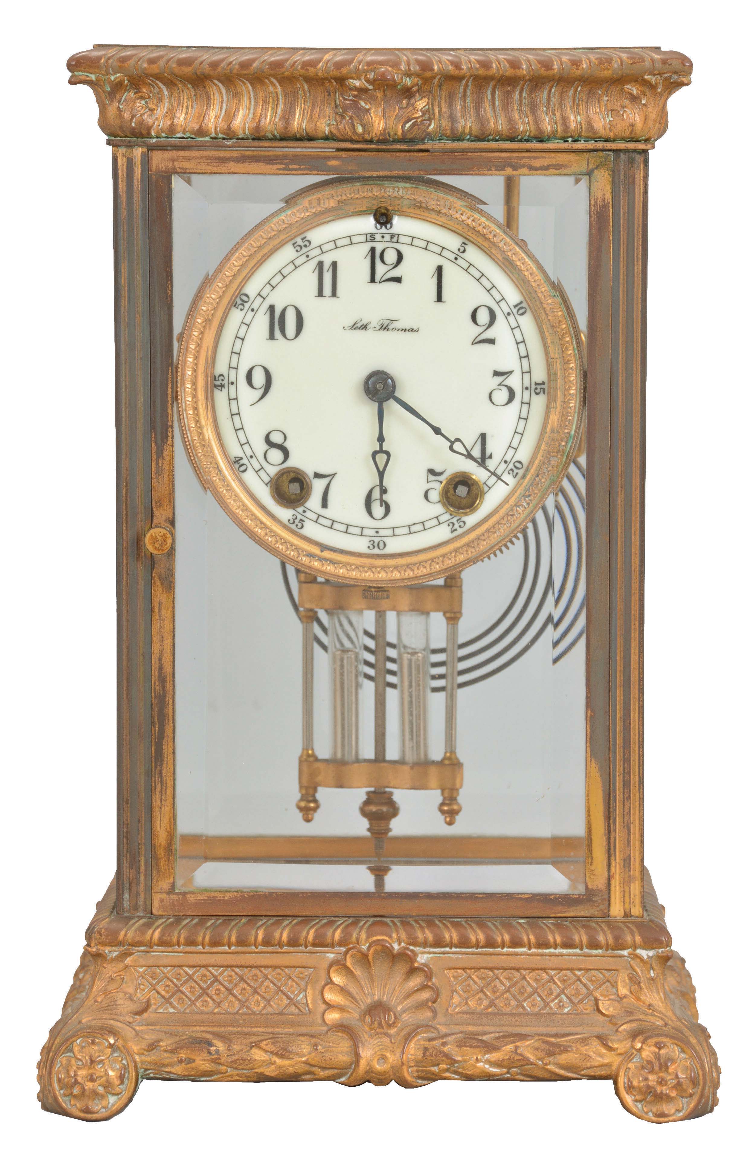 Seth Thomas Clock Co., Thomaston, Conn., "Empire No. 13" crystal regulator, 8 day, time and strike, round spring-driven movement with rack and snail strike in a gilt brass case with beveled glass front, sides, and back with a white porcelain dial and blued steel hands. — Antique Clocks Price Guide