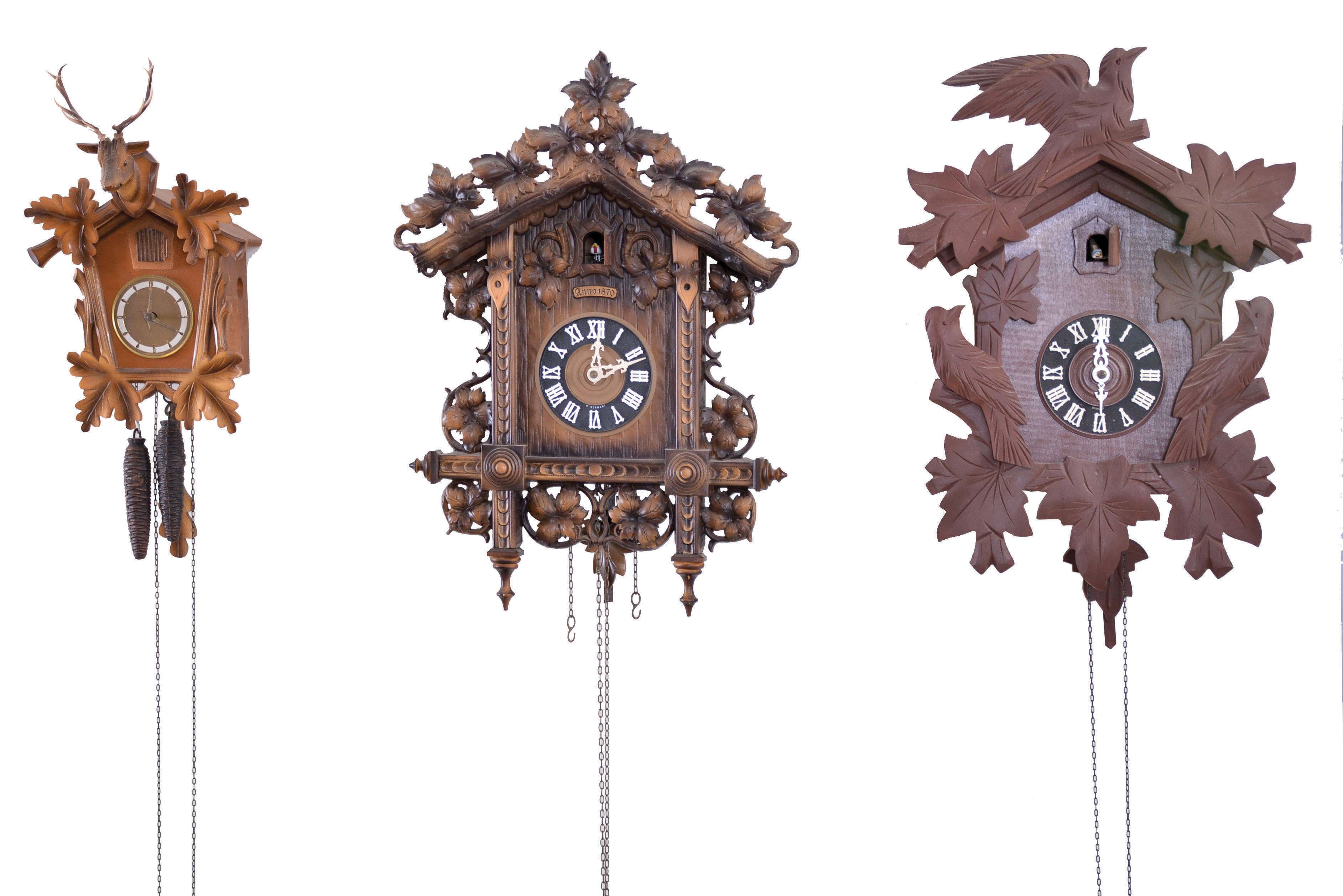 Clocks- 7 (Seven) German Cuckoo: Assortment of cuckoos, some old and some modern, including 8 day and 30 hour, two-weight movements. Two larger models, including an older clock in the hunter style with more elaborate carvings. Makers include Schmeckenbecher, Regula, G.K. (likely George Kuehl Clock Co.), Henry Coehler Co., and others that are not signed. — Antique Clocks Price Guide