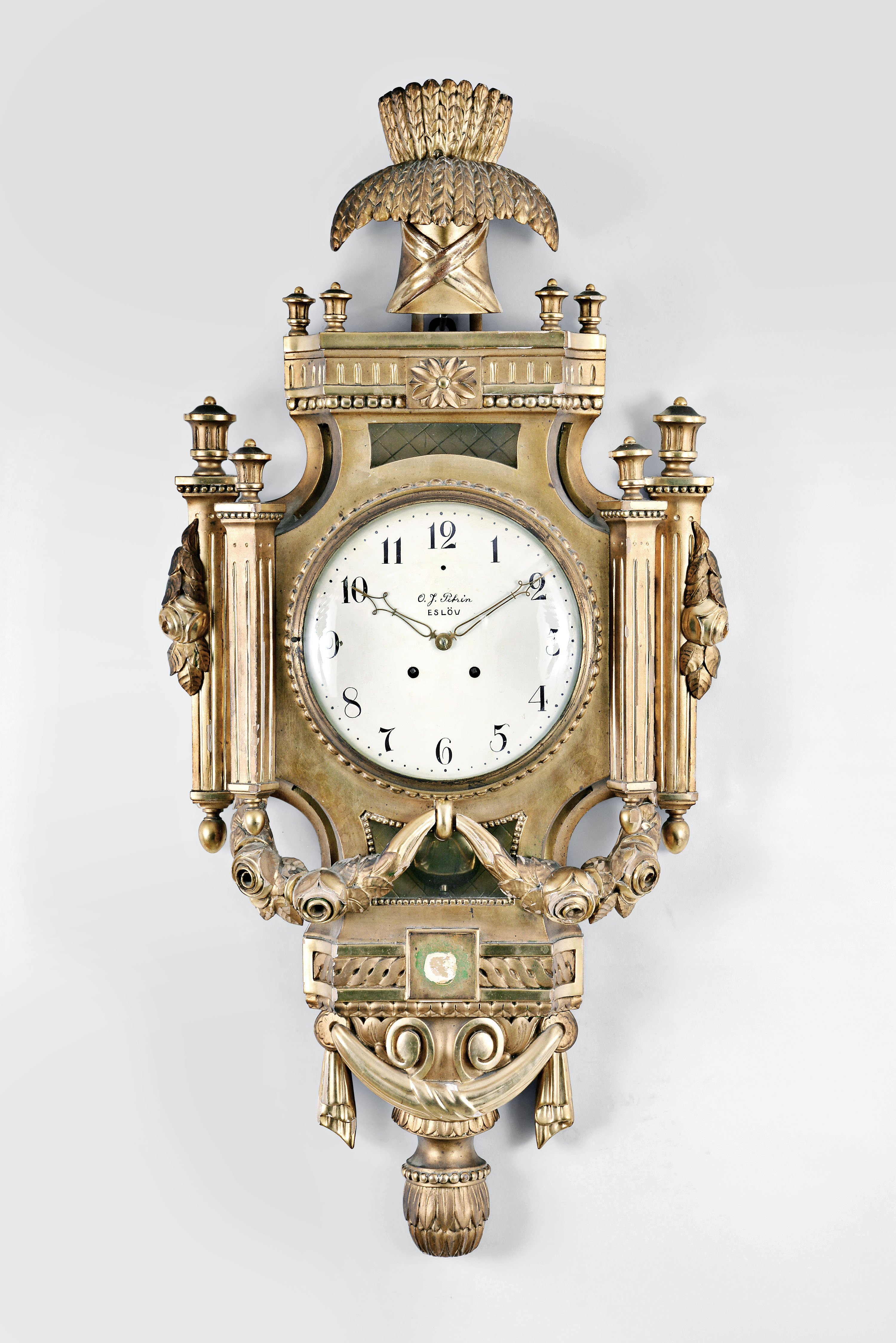 Lenzkirch AG, Lenzkirch, Germany, for the Swedish market, cartel clock, 8 day, time and strike, spring driven pendulum movement in a grand gilt wood case adorned with garlands, swags, fluted pilasters and sheaf of wheat finial, painted metal dial with Arabic numerals signed by a Swedish retailer, and gilt hands. — Antique Clocks Price Guide
