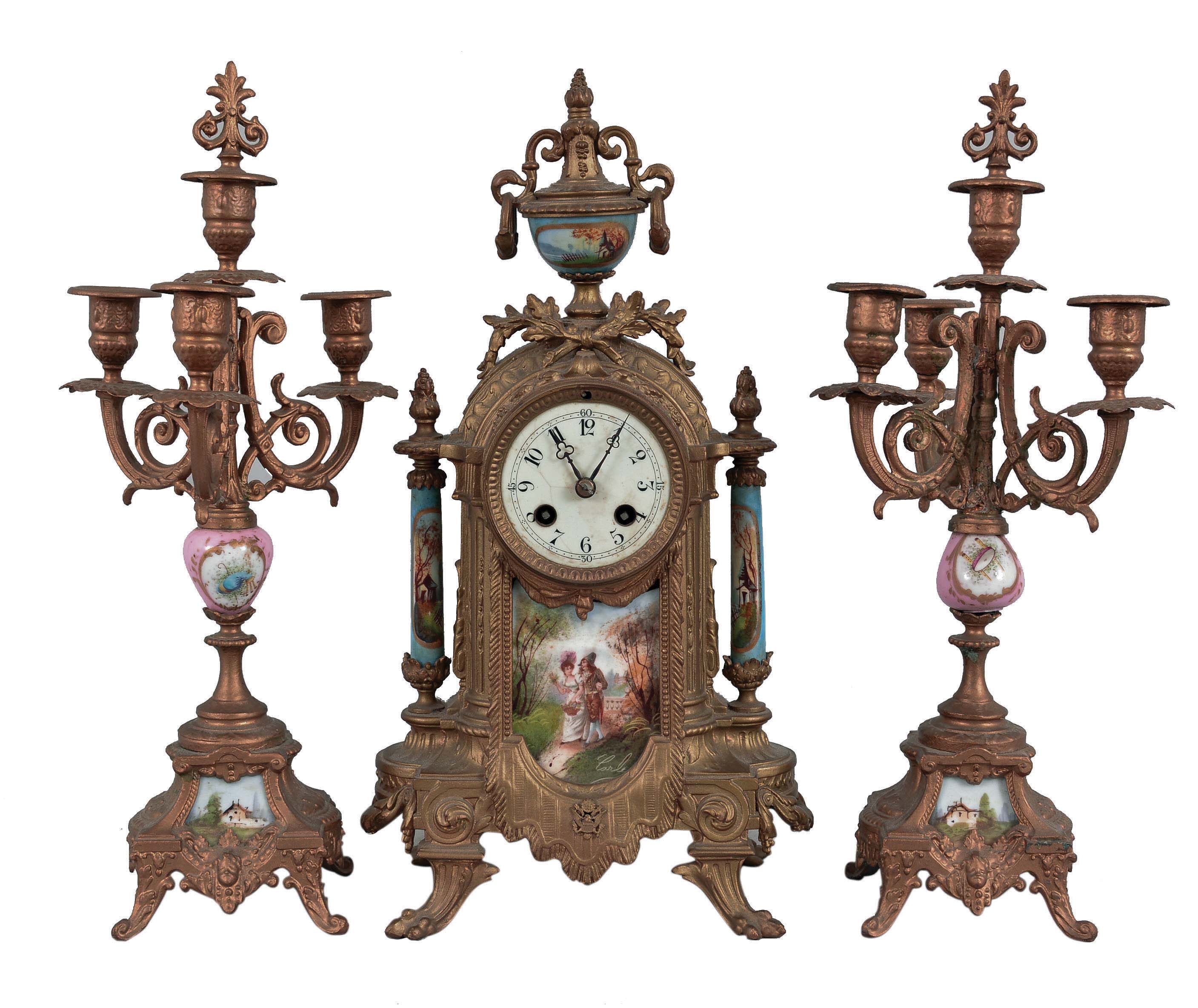 Clocks- 2 (Two) French Cast: (1) Japy Freres, Paris for Tiffany &amp; Comp., three piece mantel garniture, 8 day, time and strike, spring-driven pendule de Paris movement in an ornate cast case with gold finish, painted porcelain panels signed "Carle" and matching candelabra, c1860; (2) France, figural clock, 8 day, time and strike with alarm, spring-driven pendule de Paris movement with in a gilt brass case cast in the form of a female figure holding a bird, all mounted on an ebonized wood base. — Antique Clocks Price Guide