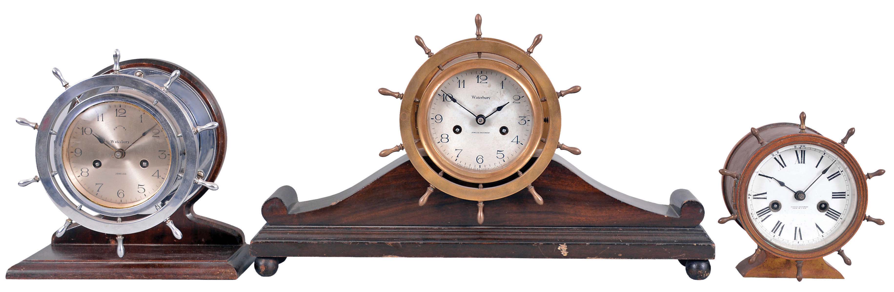 Clocks- 6 (Six) Marine and wall Clocks: most by Waterbury Clock Co. including their "Ship's Bell No. 11" on wood stand, c1915; a ship's bell in the form a yacht wheel in a nickel case on wood stand, 8 inch, c1929, an "Octagonal Lever" with simple calendar, c1909, clock portion of marine-themed desk set, c.1910 and a small octagon and a round 30 hour marine clocks with wood cases, c1900. — Antique Clocks Price Guide