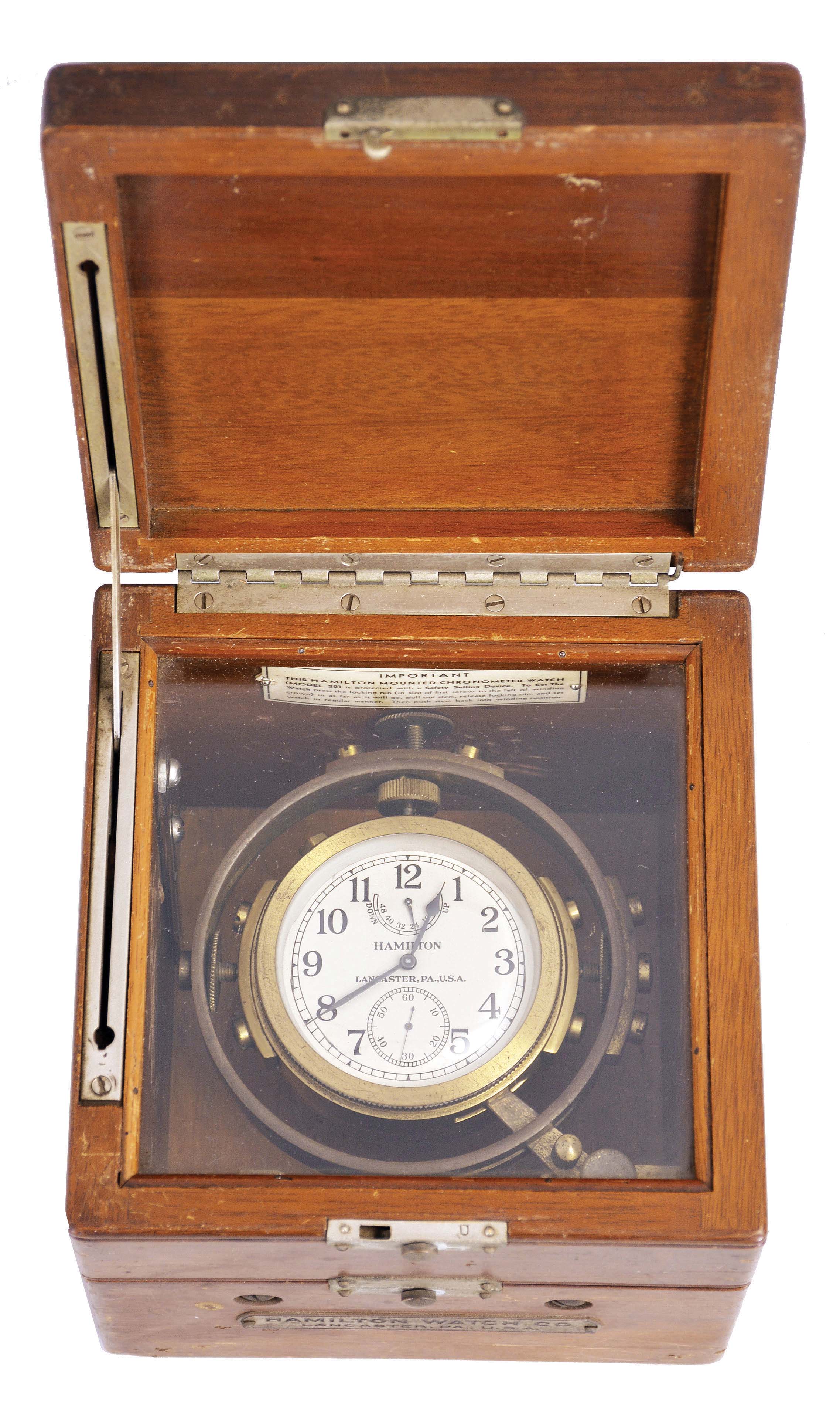 Hamilton Watch Co., Lancaster, Penn., model 22 chronometer watch with wind indicator, 35 size, 21 jewels, stem wind, pin set, adjusted to 6 positions and temperature, straight line damascened nickel plate movement, with lever escapement and micrometric regulator, Arabic numeral silvered metal dial, black steel spade and poker hands, the timepiece contained in a correct but associated gimbaled bowl, and mounted in a mahogany box, and with padded cherry outer box with leather strap, movement marked "U.S. Navy Bu. Ships- 1942", serial #2F4289 — Antique Clocks Price Guide