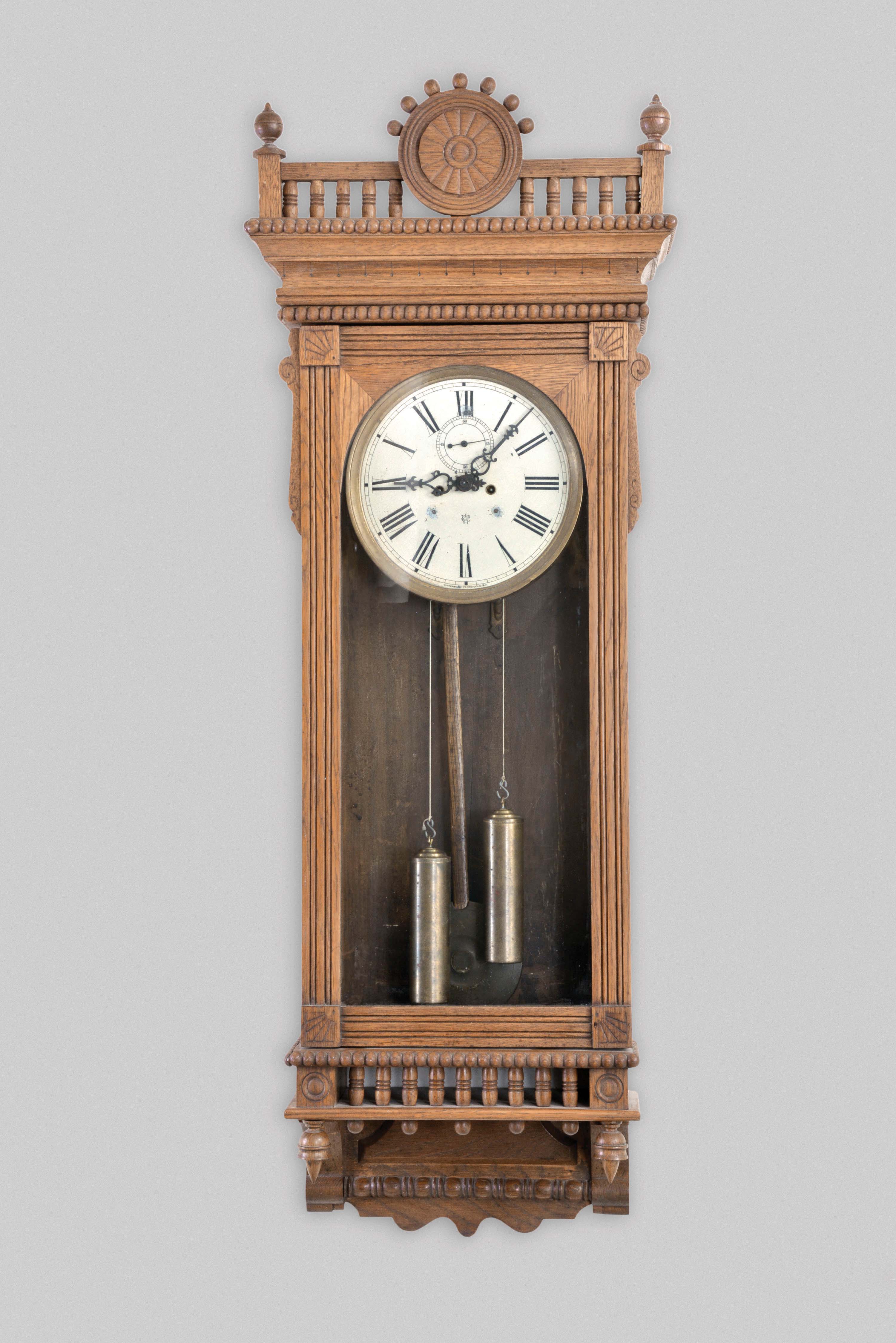 Waterbury Clock Co., Waterbury, Conn., "Regulator No. 53", wall clock, 8 day, time only, two brass weight driven movement in an oak case with a painted metal dial — Antique Clocks Price Guide
