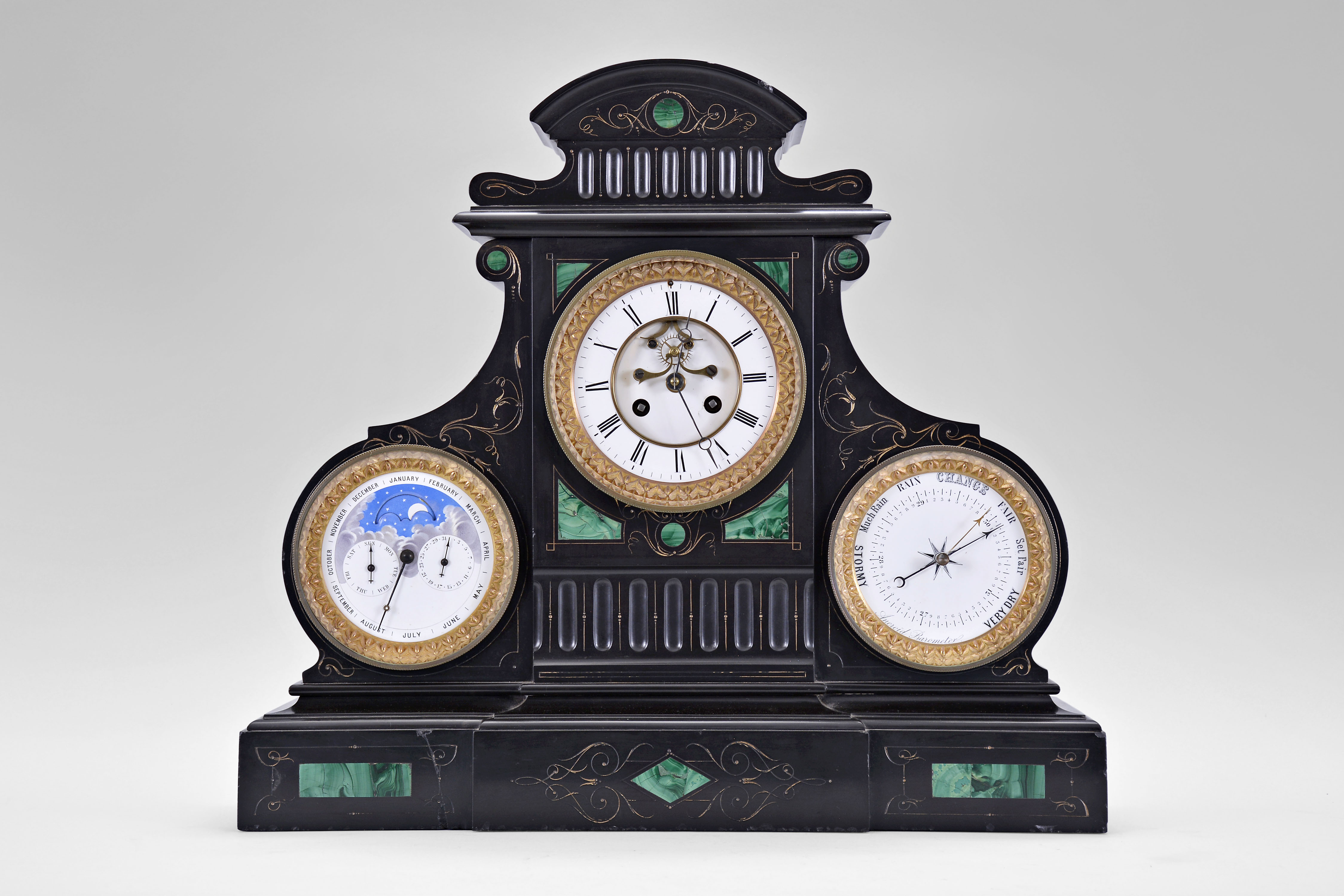 France, monumental mantel clock, 8 day, time and strike, spring driven movement with triple calendar, moon phases and barometer in a black slate case with green malachite insets and incised gold highlights. All dials are white enamel and the clock has exposed Brocot escapement on center dial. — Antique Clocks Price Guide