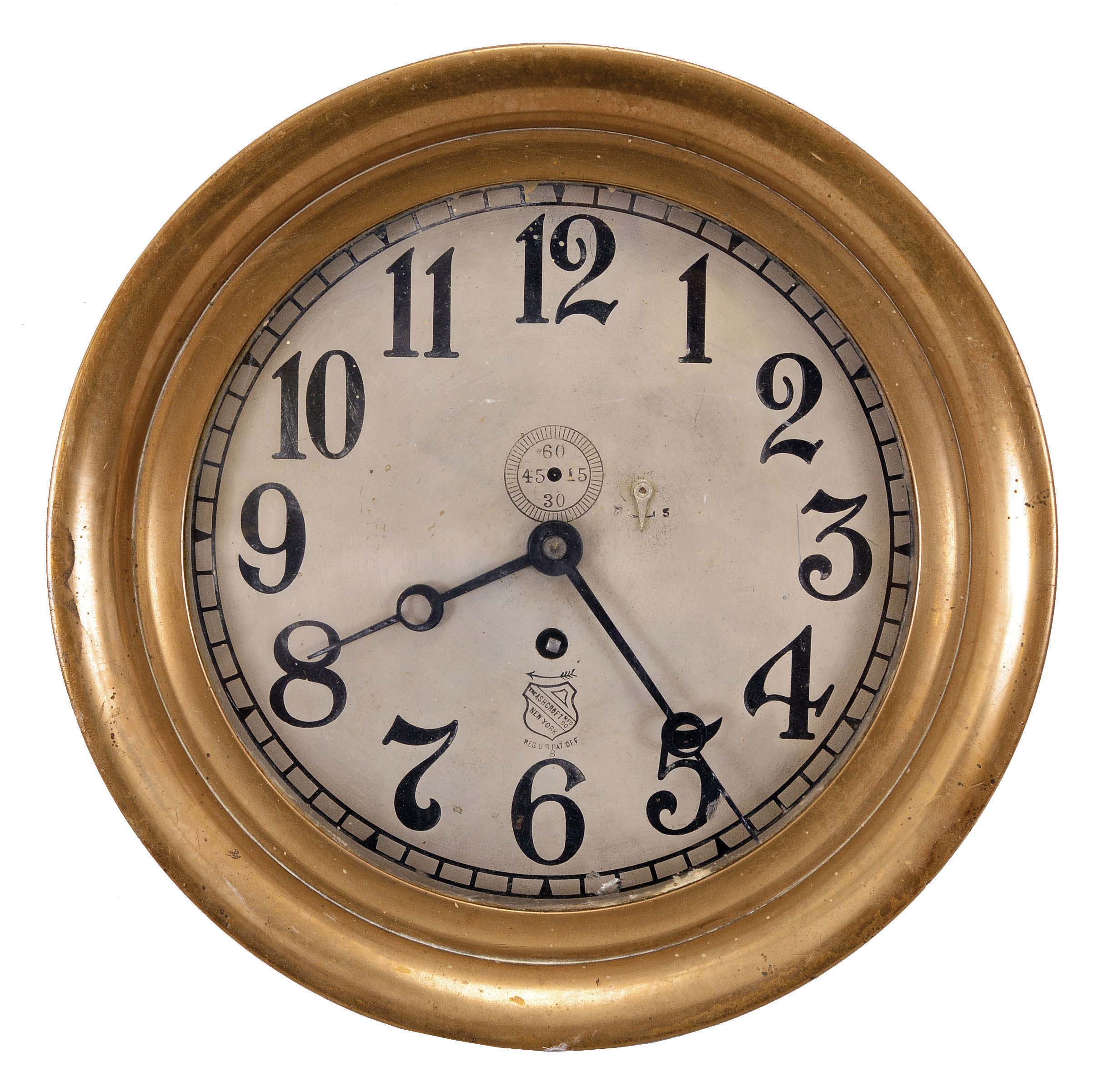 Chelsea Clock Co., Boston, Mass., for The Ashcroft Mfg. Co., New York, engine room clock, 8 day, time only, spring-driven jeweled balance wheel movement in a brass case with hinged bezel, 8 inch silvered dial with Arabic numerals, the Ashcroft trademark, and subsidiary seconds, blued steel hands. — Antique Clocks Price Guide