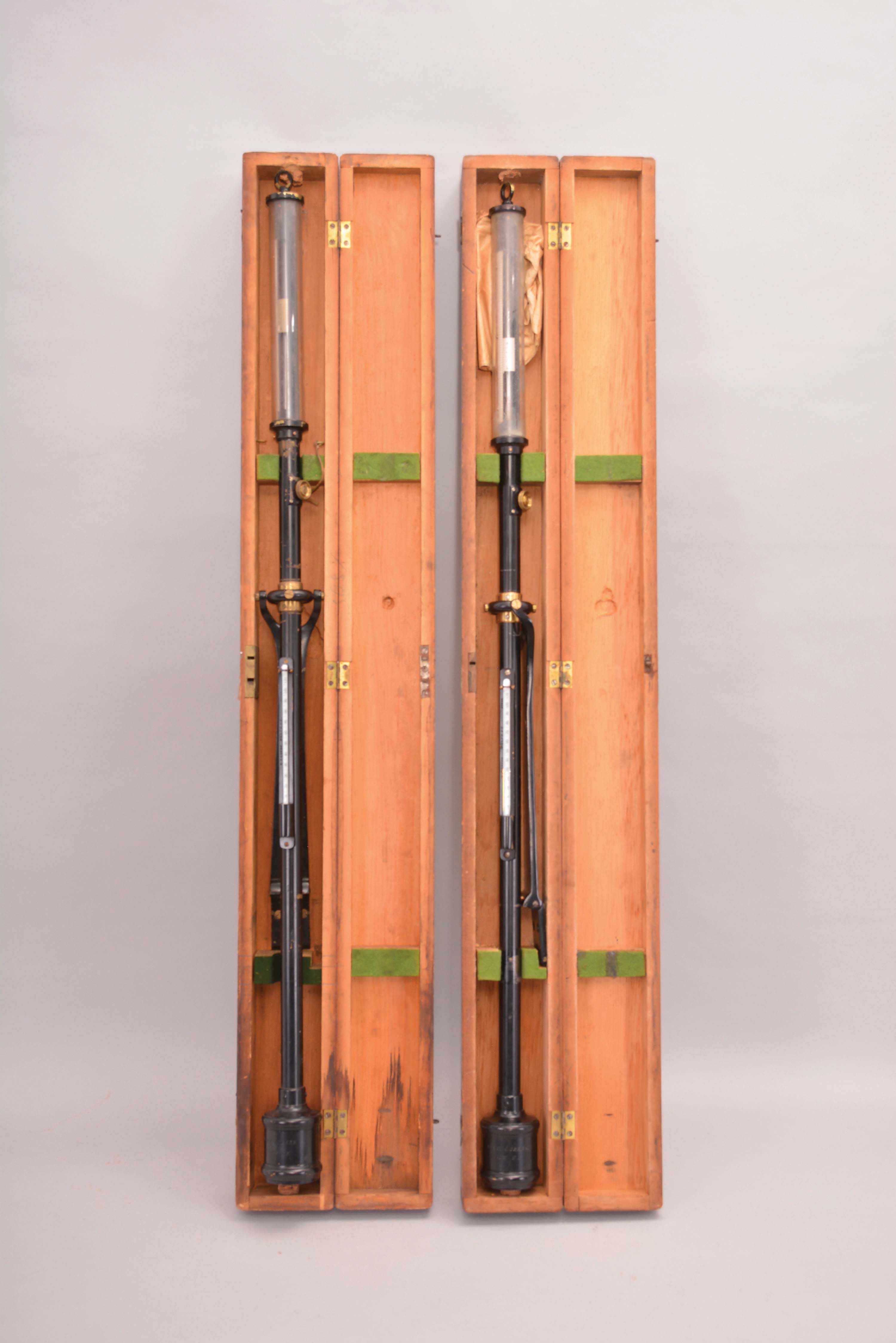 Barometers- 2 (Two) Henry J. Green, Brooklyn, New York, stick barometers, in black metal cases with brass hardware, silvered scales reading 26 to 33 with small vernier scale, thermometers on the outside of instruments, all in fitted finger-jointed wood cases with gimbaled mounts. — Antique Clocks Price Guide