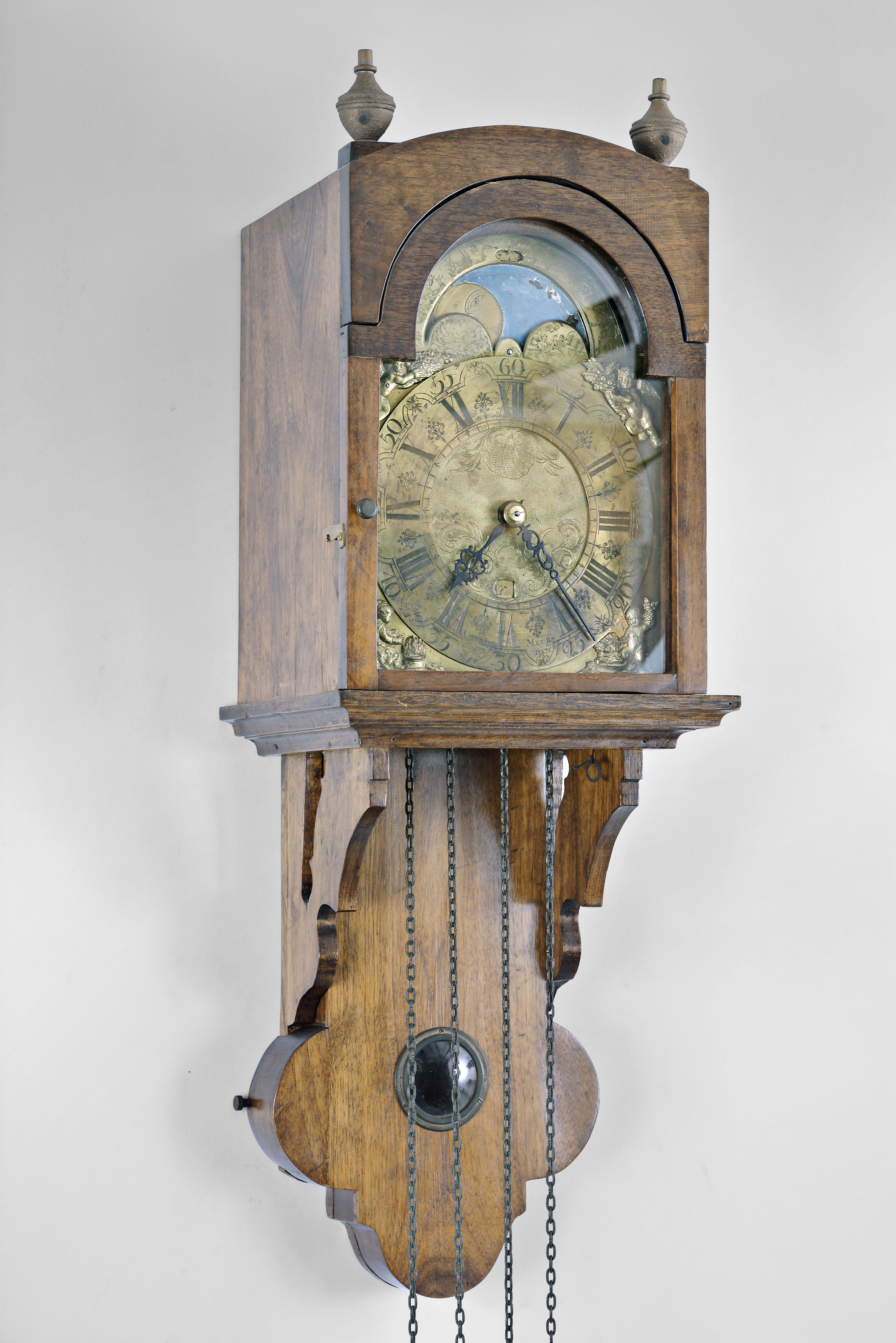 Otto Van Meurs, Amsterdam, Netherlands, wall clock, 3 day, time and strike with calendar and moon phase, weight driven movement in an associated mahogany case, engraved brass dial and chapter ring, applied cast spandrels, and pierced steel hands. — Antique Clocks Price Guide